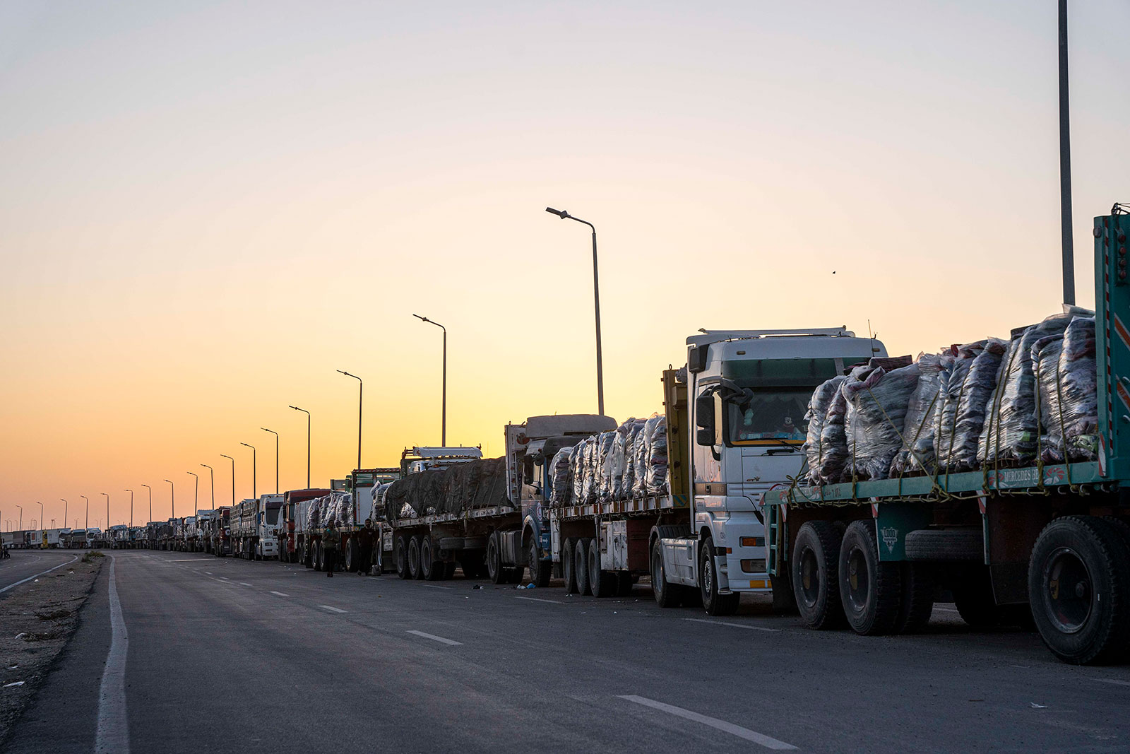 Trucks with aid destined for the Gaza are parked on the side of the road in Rafah, Egypt, on Monday, December 11.