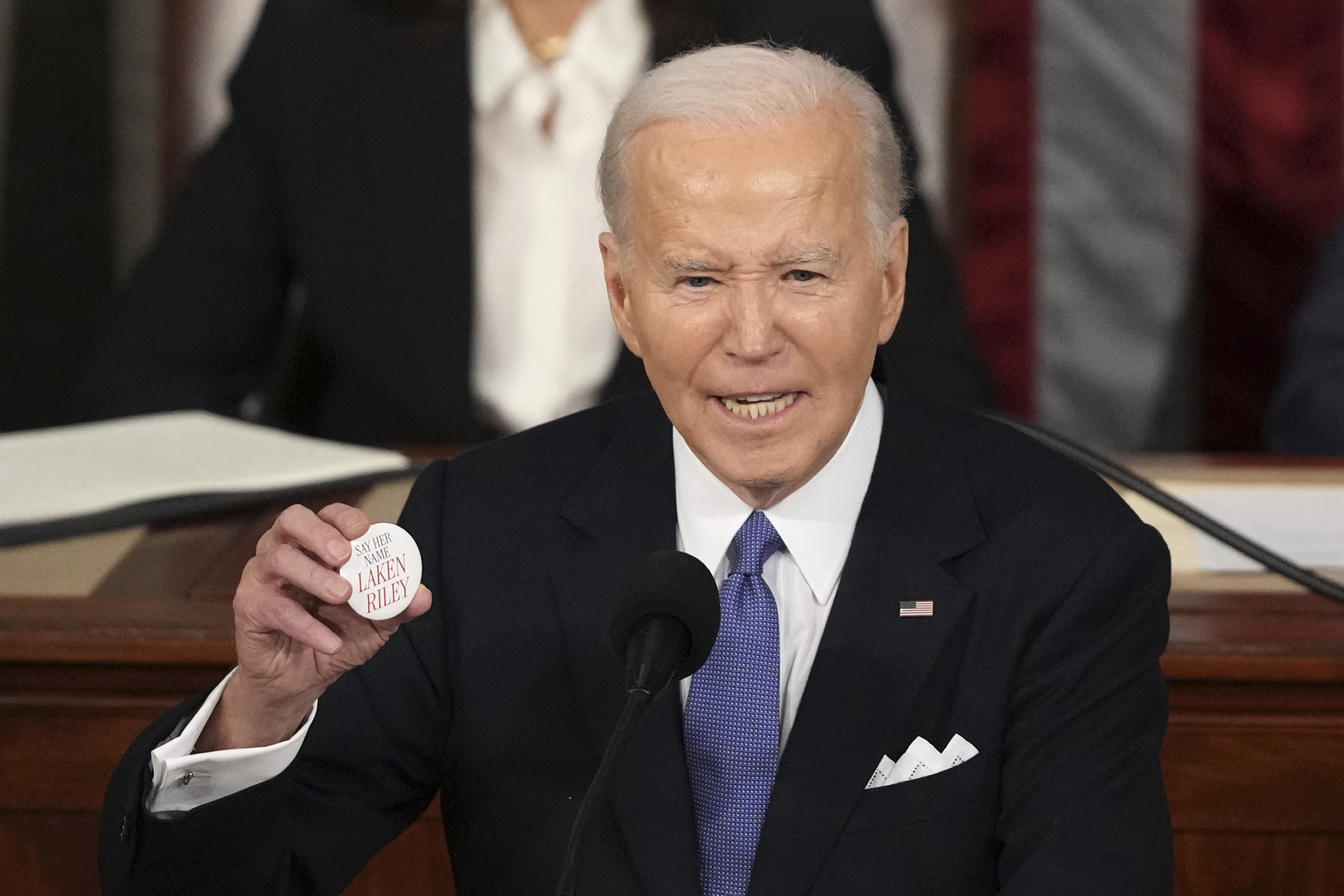 President Joe Biden holds up a button with Laken Riley's name as he delivers his State of the Union address at the Capitol in Washington, DC, on March 7.