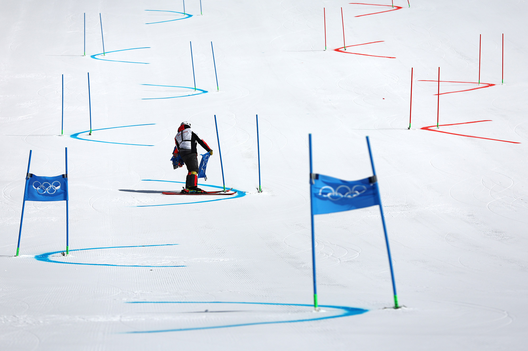 A course worker removes gate flags after the alpine skiing mixed team event was postponed due to poor weather conditions on Saturday.