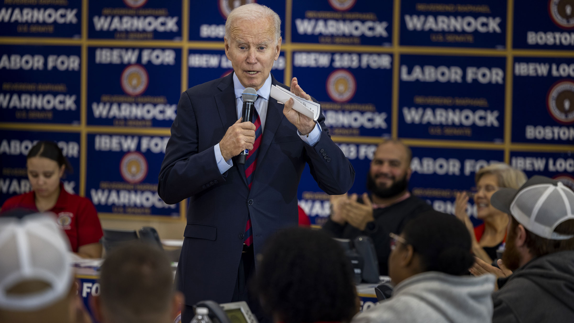 President Joe Biden speaks to volunteers in Boston working at an International Brotherhood of Electrical Workers phone-banking event Friday for US Sen. Raphael Warnock.