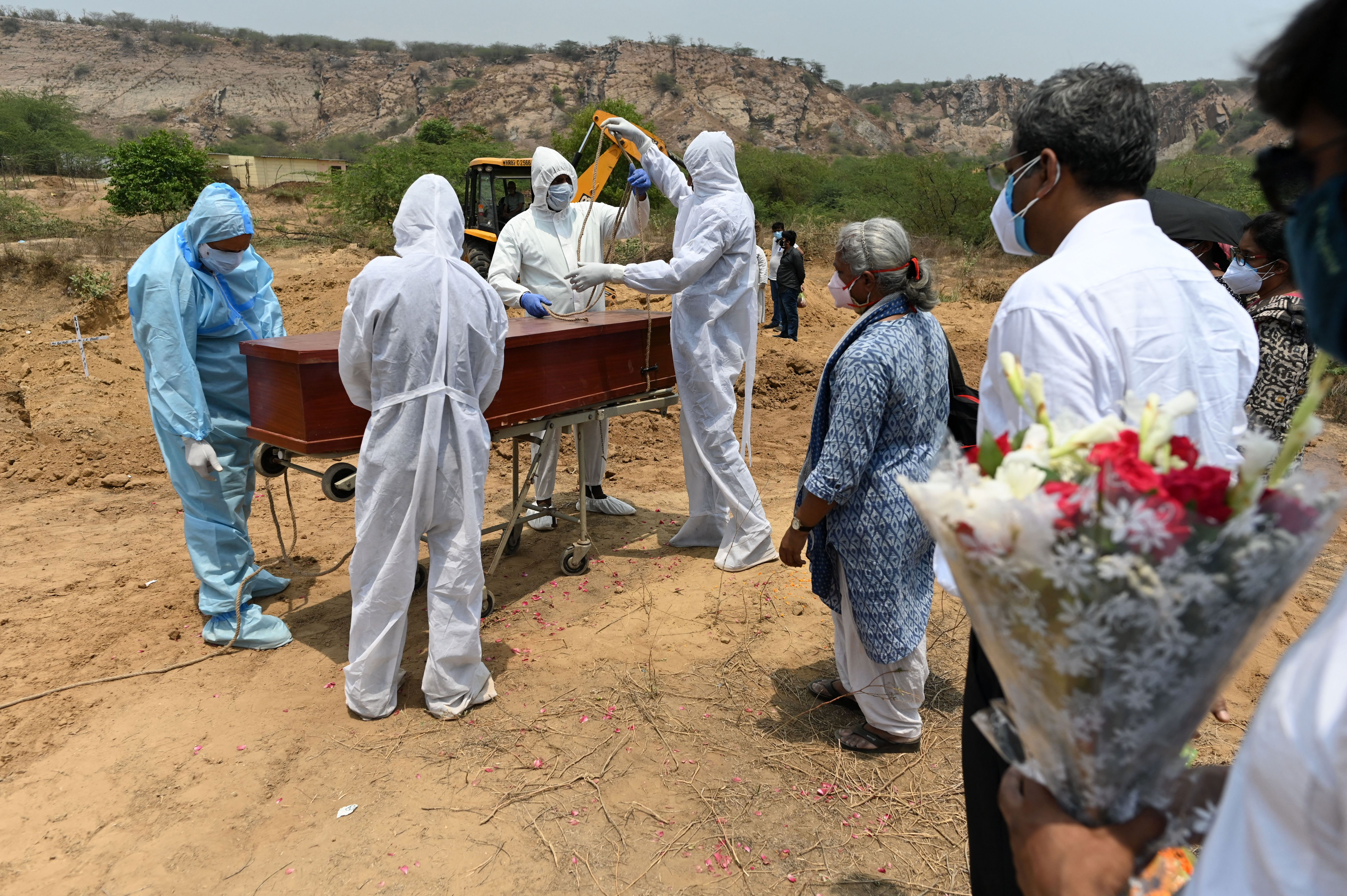 Ambulance service employees seal the coffin of a Covid-19 victim before burial at a cemetery in the village of Pali, near Faridabad, in India on May 8.