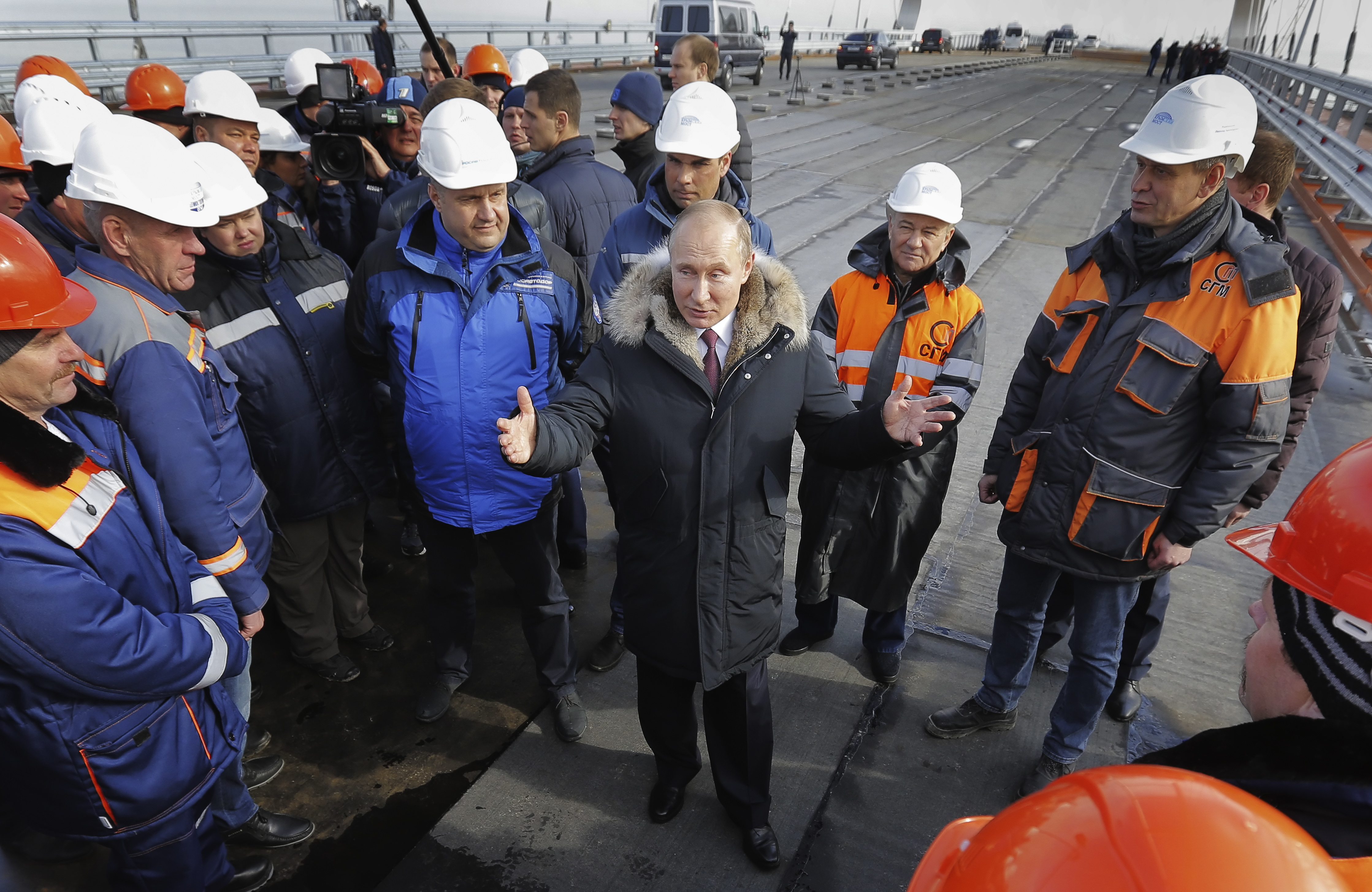 Russian President Vladimir Putin, centre, speaks with workers visiting the road section of the road-rail bridge linking Crimea to mainland Russia near Kerch, Crimea, on March 14, 2018. Putin hailed the bridge, which is set to be completed later this year, as a major engineering achievement and praised those involved in its construction.