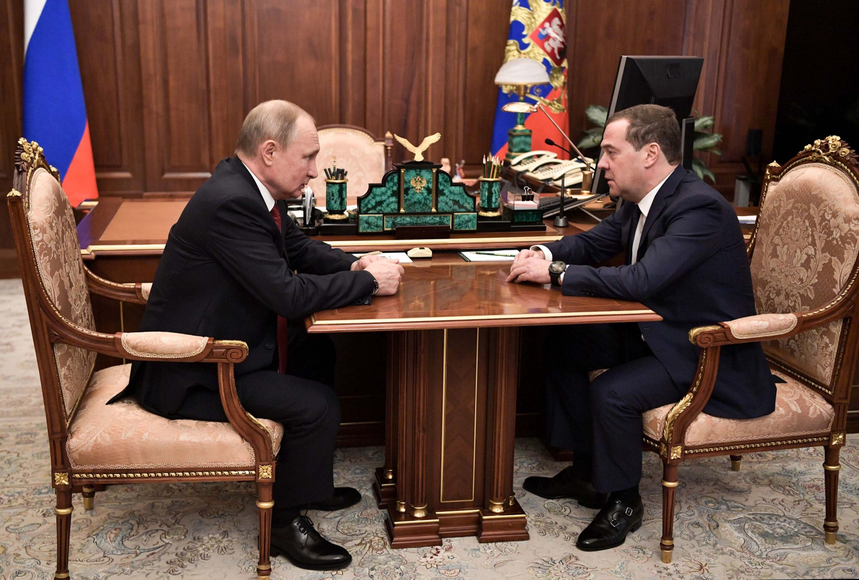 Russian President Vladimir Putin sits down with Prime Minister Dmitry Medvedev in Moscow on Wednesday.