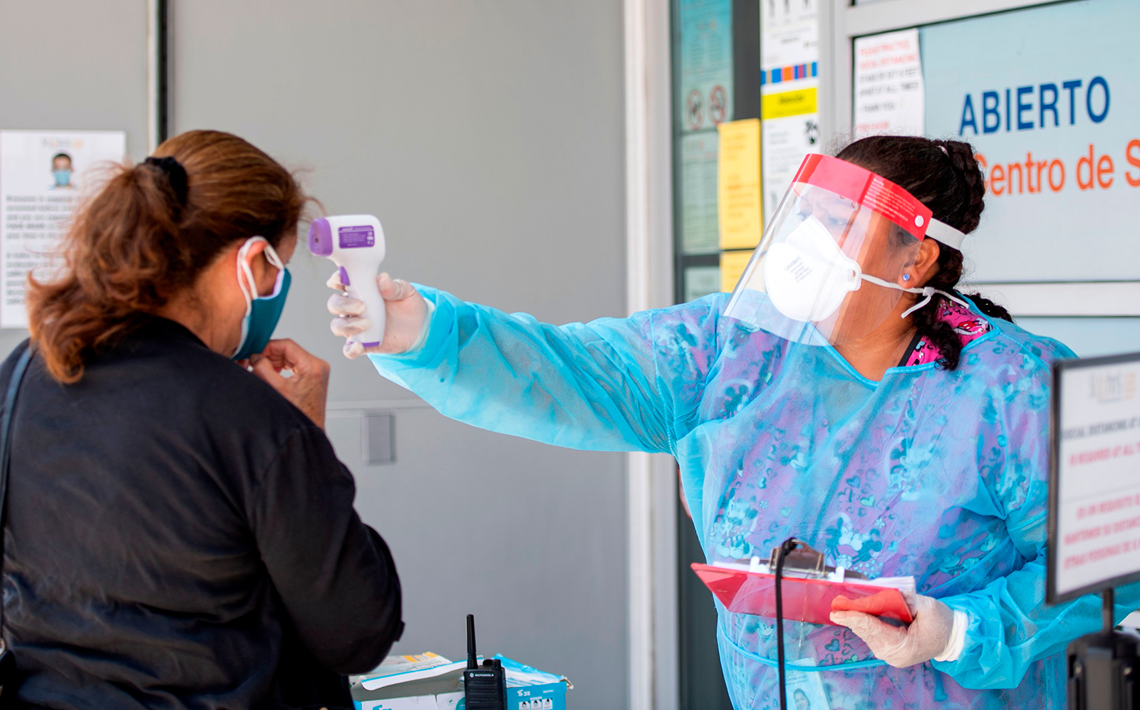 A health worker takes a patient's temperature before sending them to a tent to be tested at a Covid-19 testing site in Los Angeles on July 24.