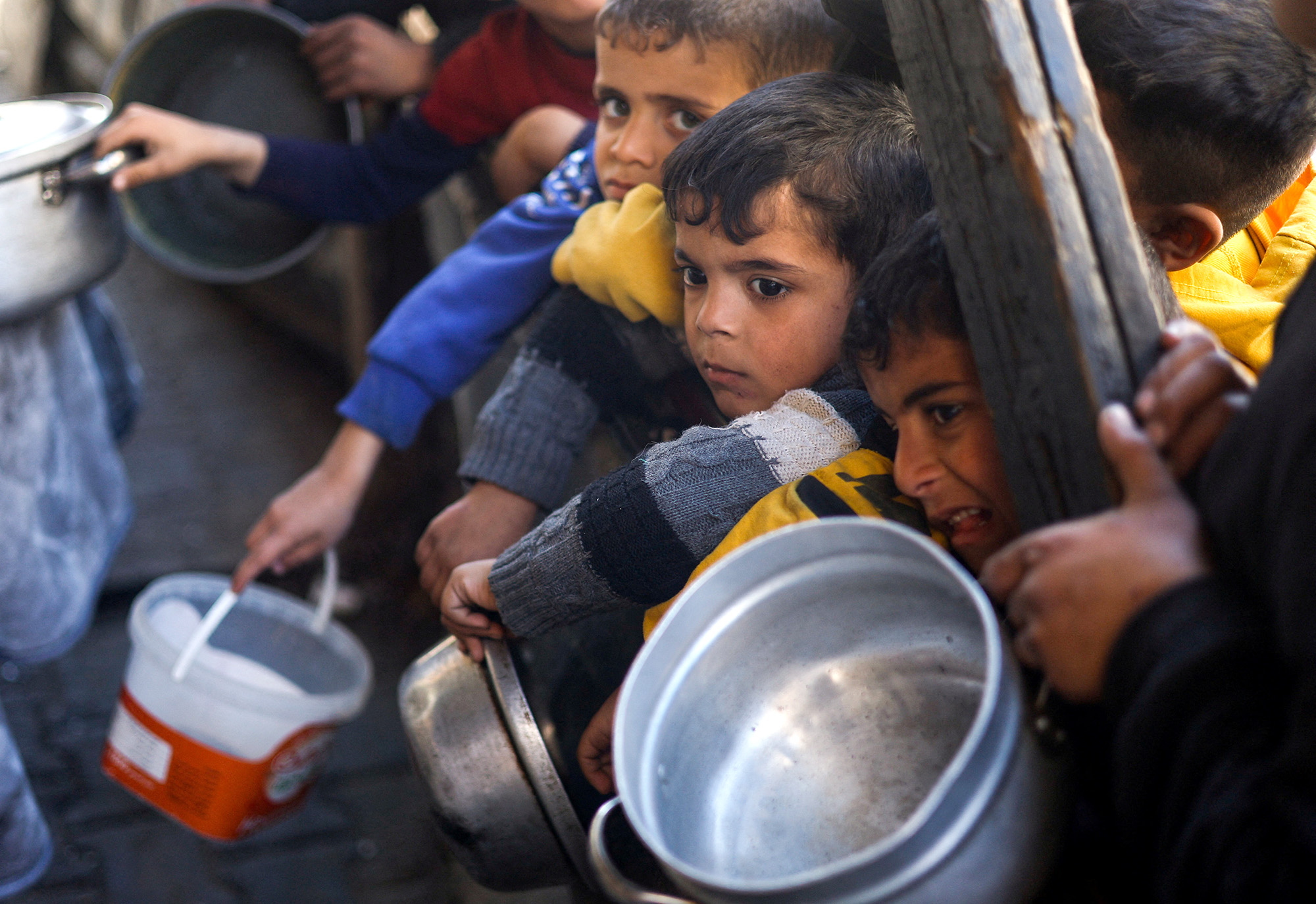 Palestinian children wait to receive food cooked by a charity kitchen amid shortages of food supplies in Rafah, Gaza, on March 5.