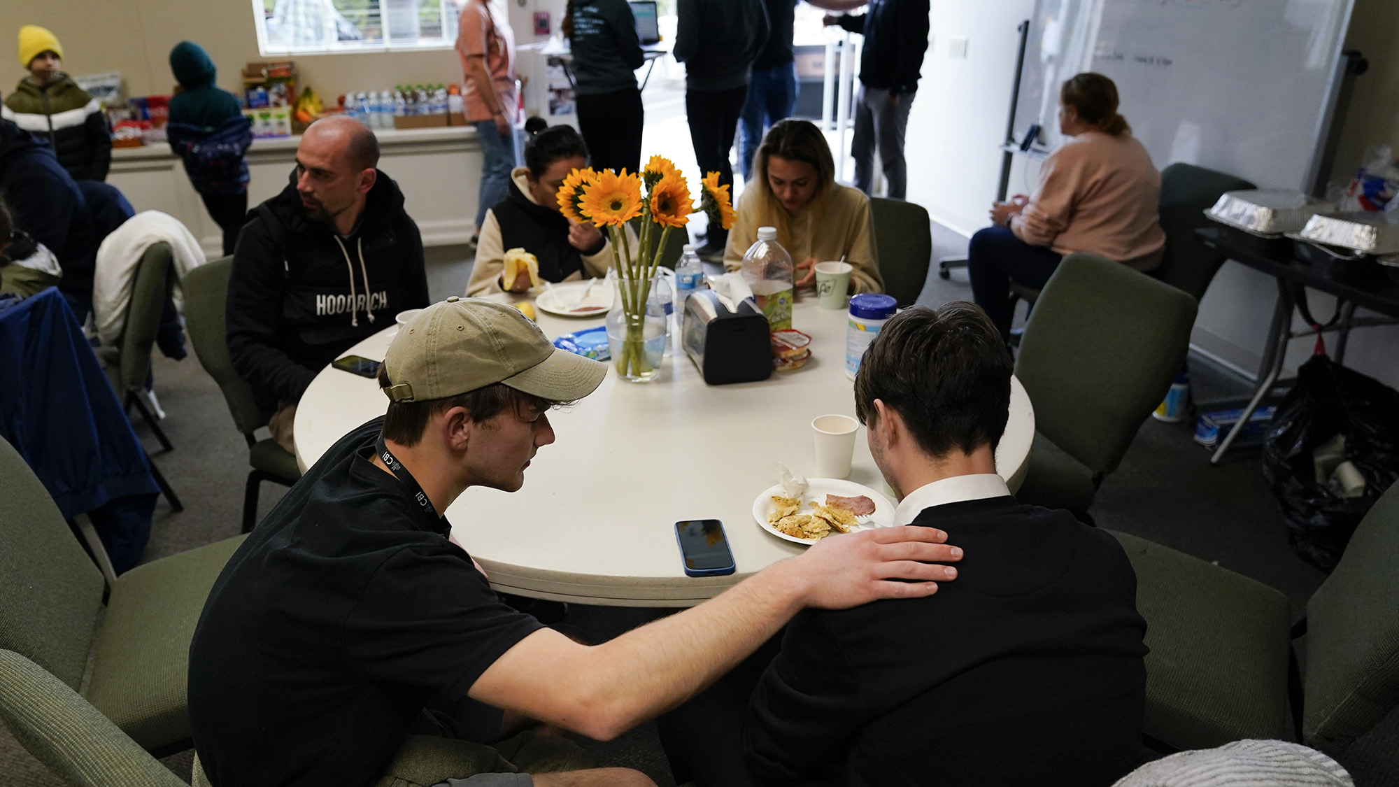 Volunteer Silas Breen, left, from the Calvary Bible Institute, prays with David, from Ukraine, at San Diego Calvary's shelter for Ukrainians after crossing into the United States from Tijuana, Mexico on Friday, April 1.