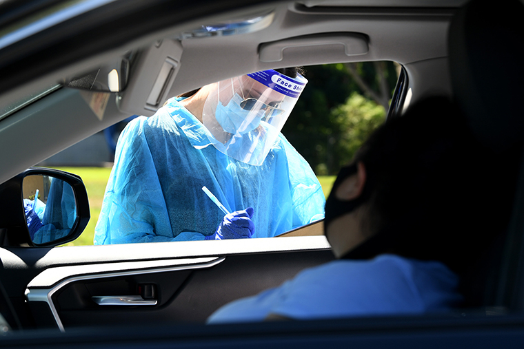 An urgent care worker performs drive-up COVID-19 testing at James Jordan Middle School on August 10, 2020 in Winnetka, California. 