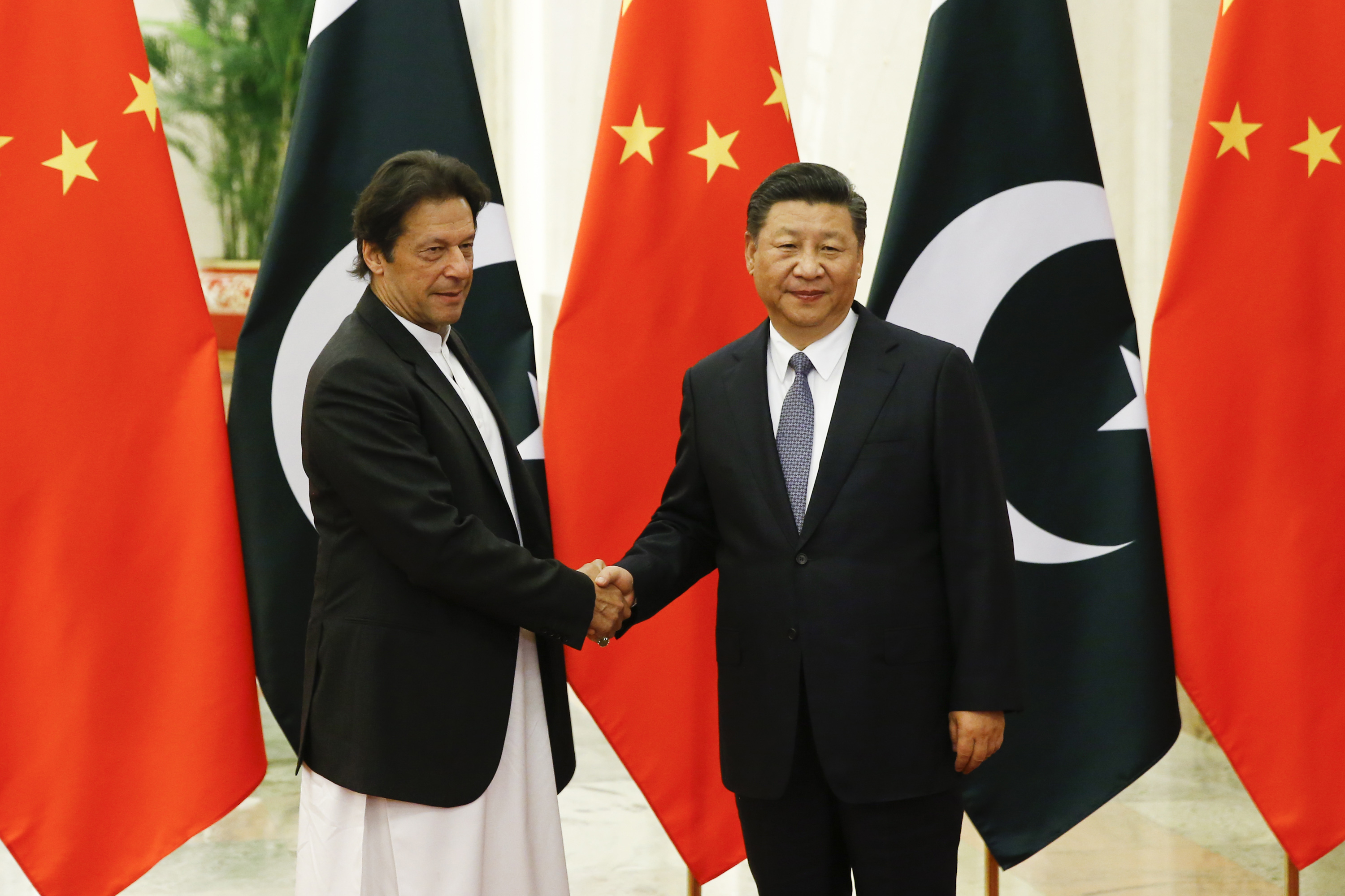 China's President Xi Jinping (R) shakes hands with Pakistan's Prime Minister Imran Khan at the Great Hall of the People in Beijing on November 2, 2018.
