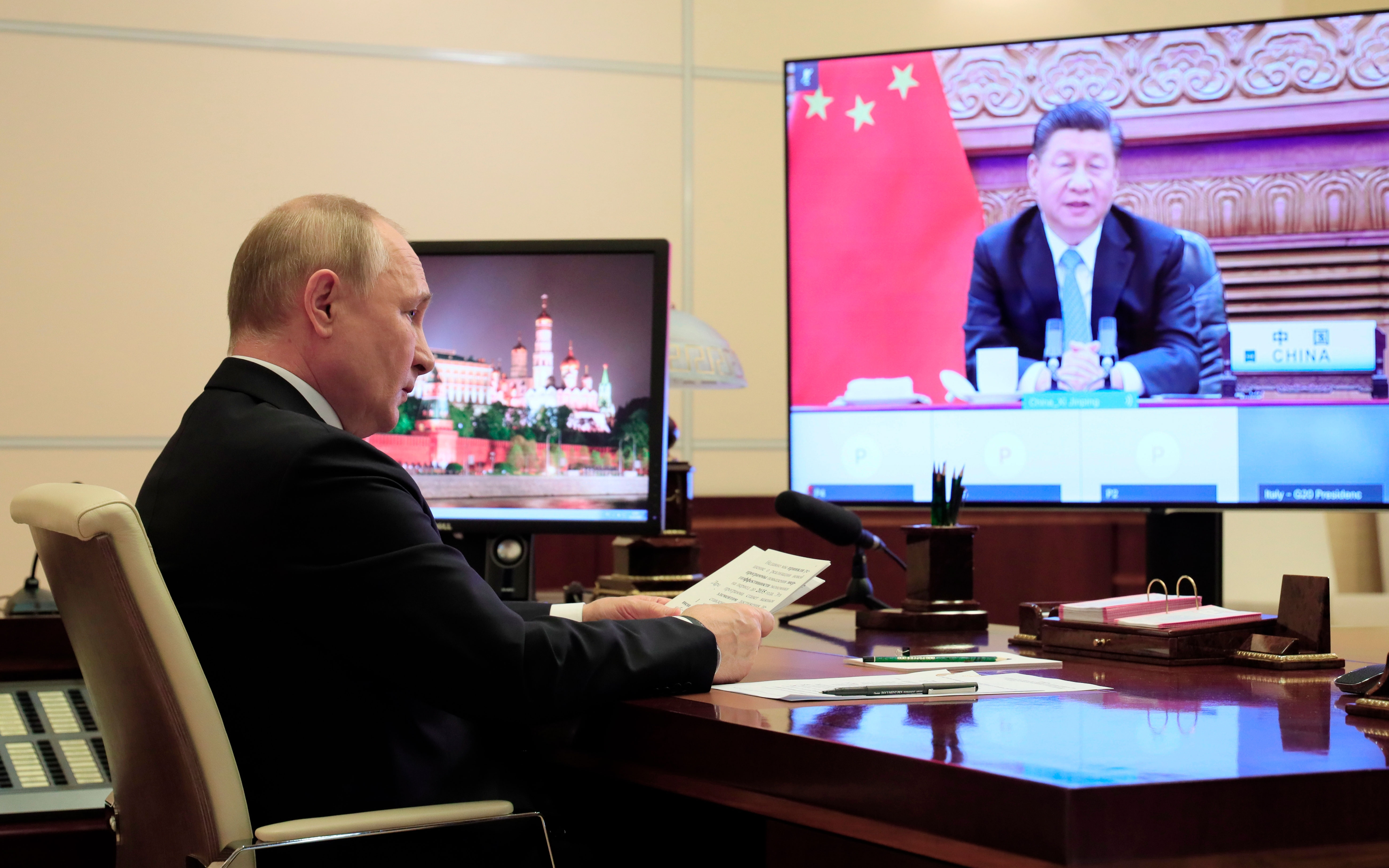 Russia's President Vladimir Putin attends the G20 summit via video at the Novo-Ogaryovo residence outside Moscow on October 31. China's President Xi Jinping is on the display.