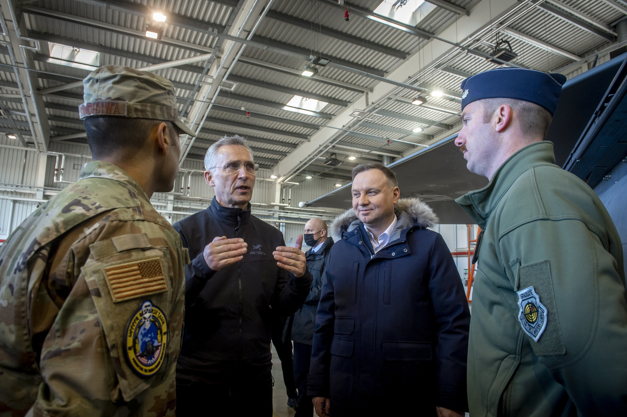 NATO Secretary General Jens Stoltenberg (2nd left) and Polish President Andrzej Duda (2nd right) speak with NATO officers at the military air base in Lask, Poland on March 1.
