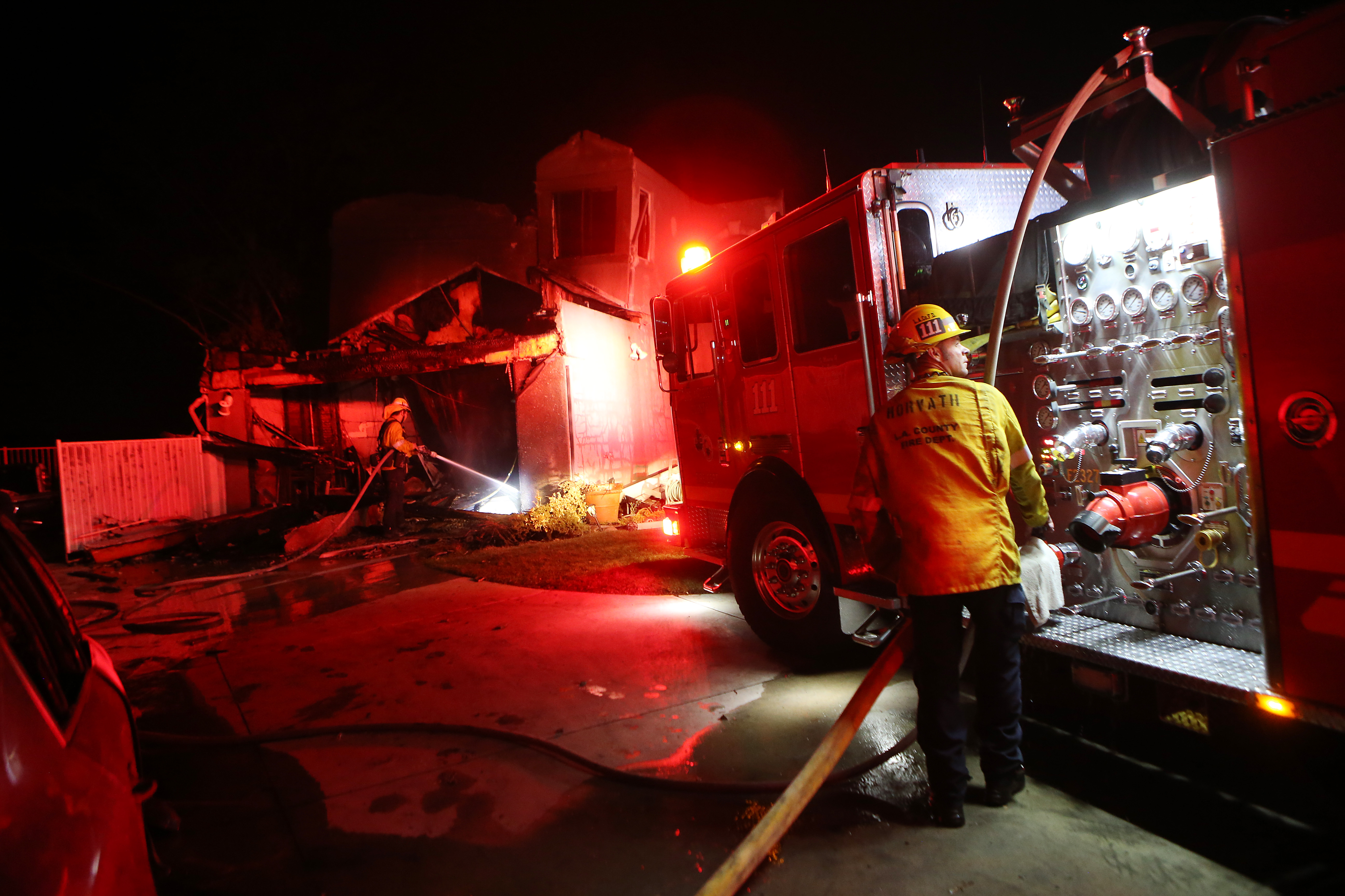 Los Angeles County Fire Department firefighters work at a home destroyed by the Tick Fire on October 24, 2019 in Canyon Country, California.