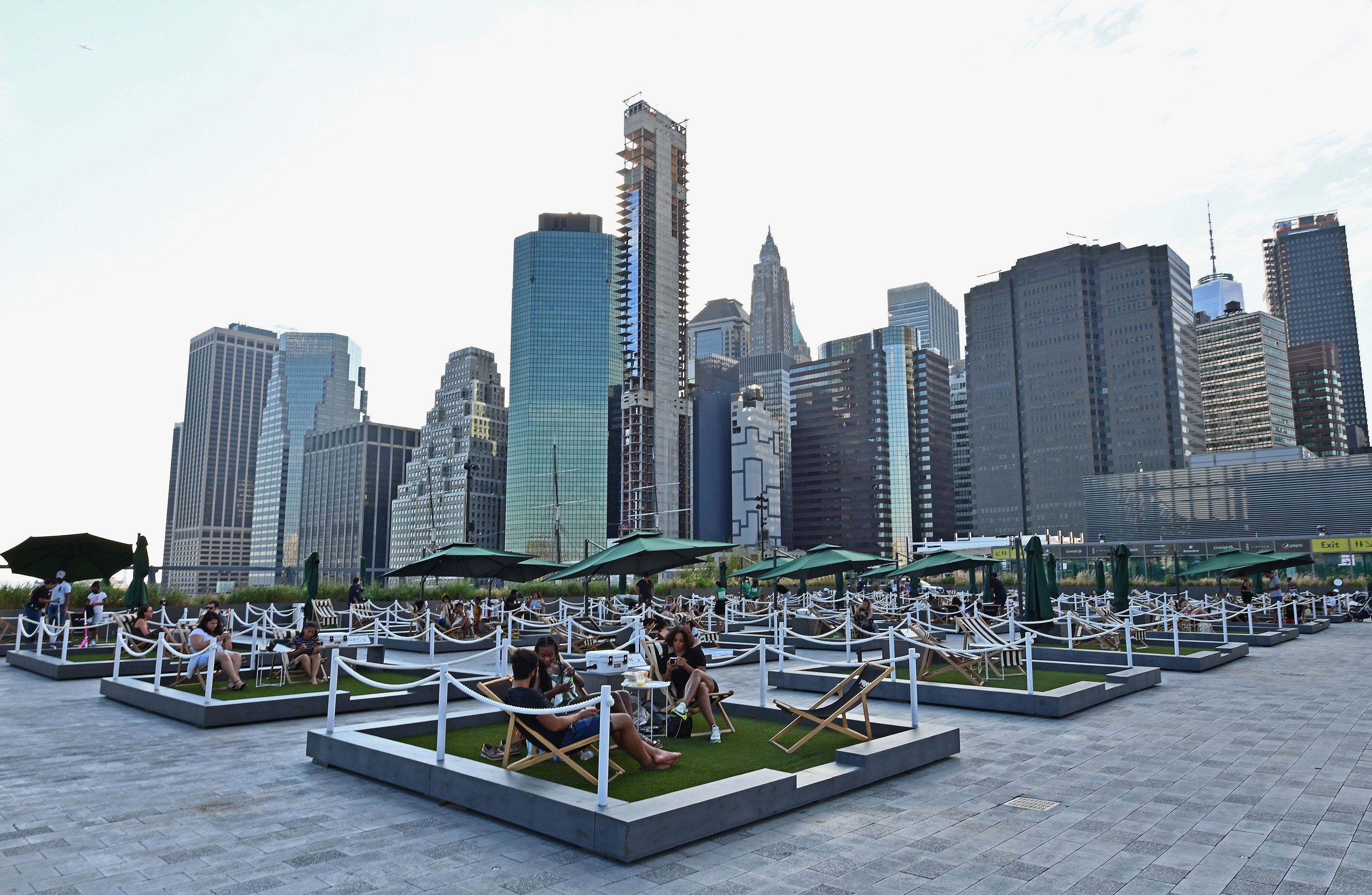 People relax on socially distant mini-lawns on the rooftop of Pier 17 in the Seaport District of New York City on August 14.