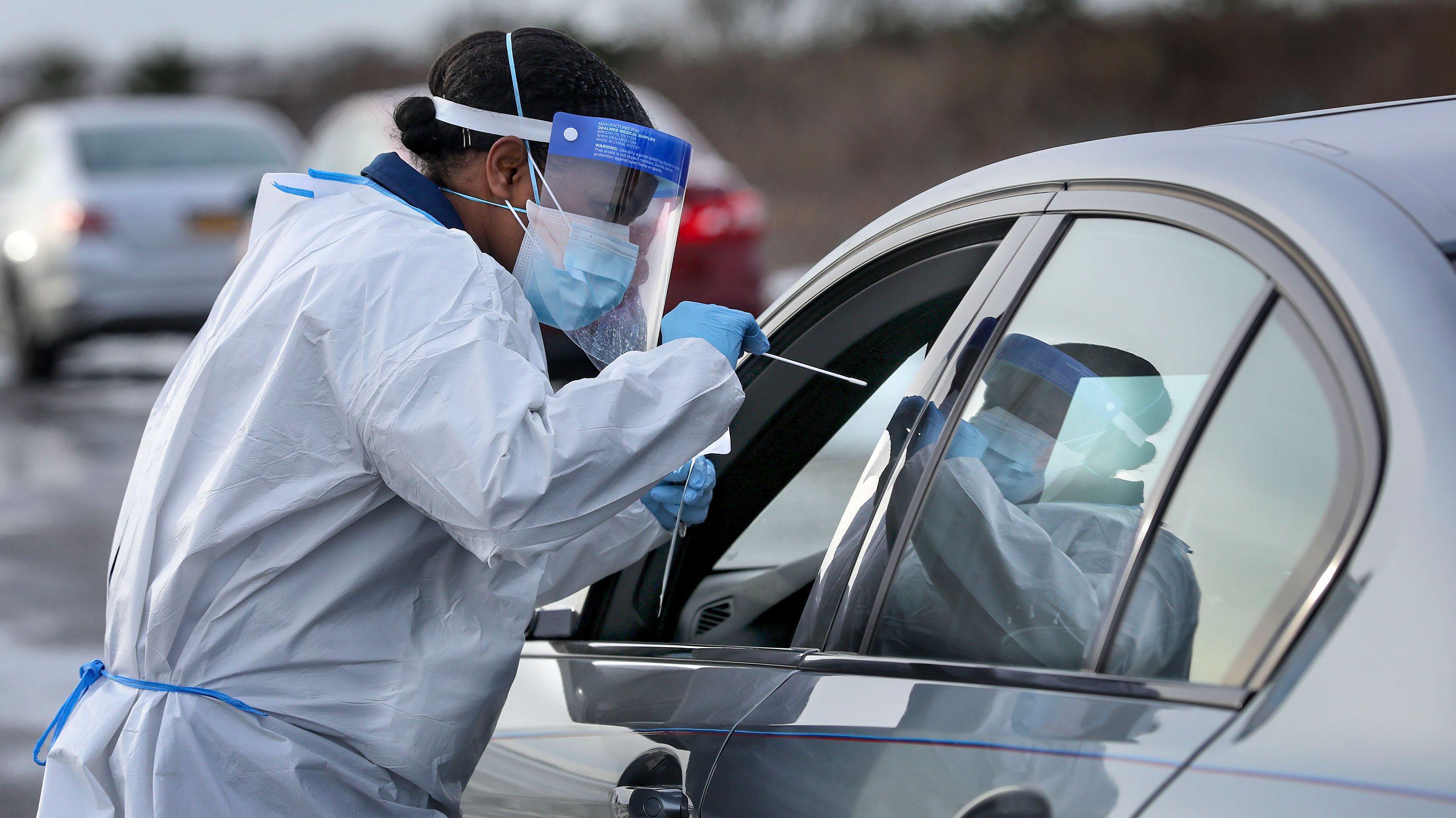 A nurse administers a Covid-19 swab test at a drive-thru testing site in Shirley, New York, on December 19.