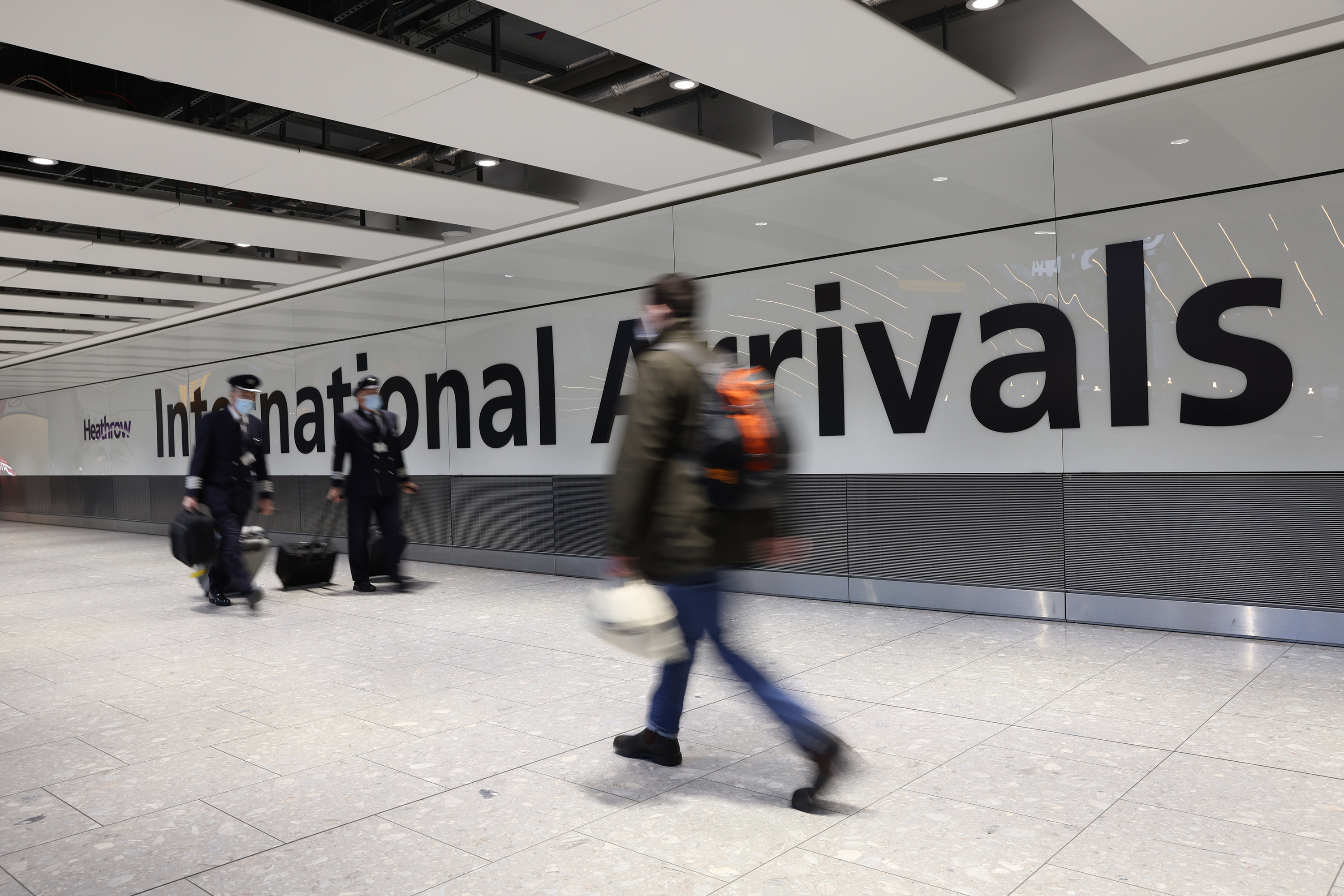 Travelers pass through the international arrivals gate at Heathrow Airport on November 28, in London, England. 