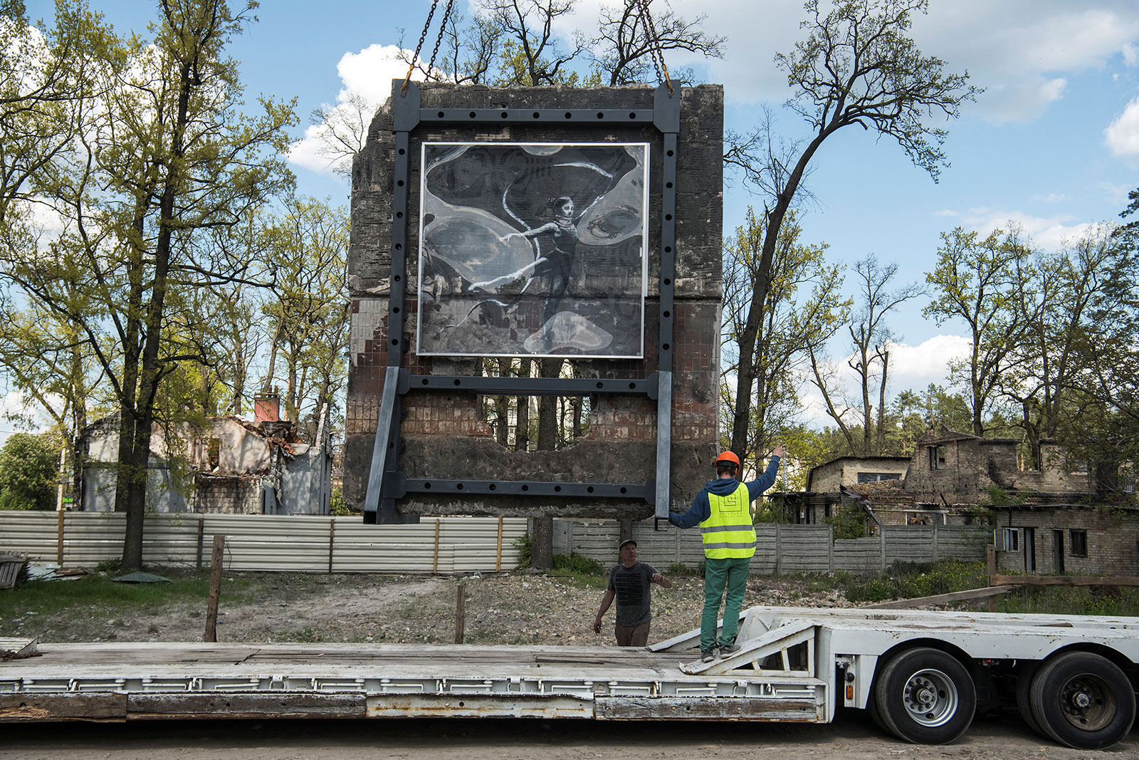 Workers unload the portion of a wall featuring the artwork after it was  dismounted from the heavily damaged residential in Irpin, Ukraine on May 13.