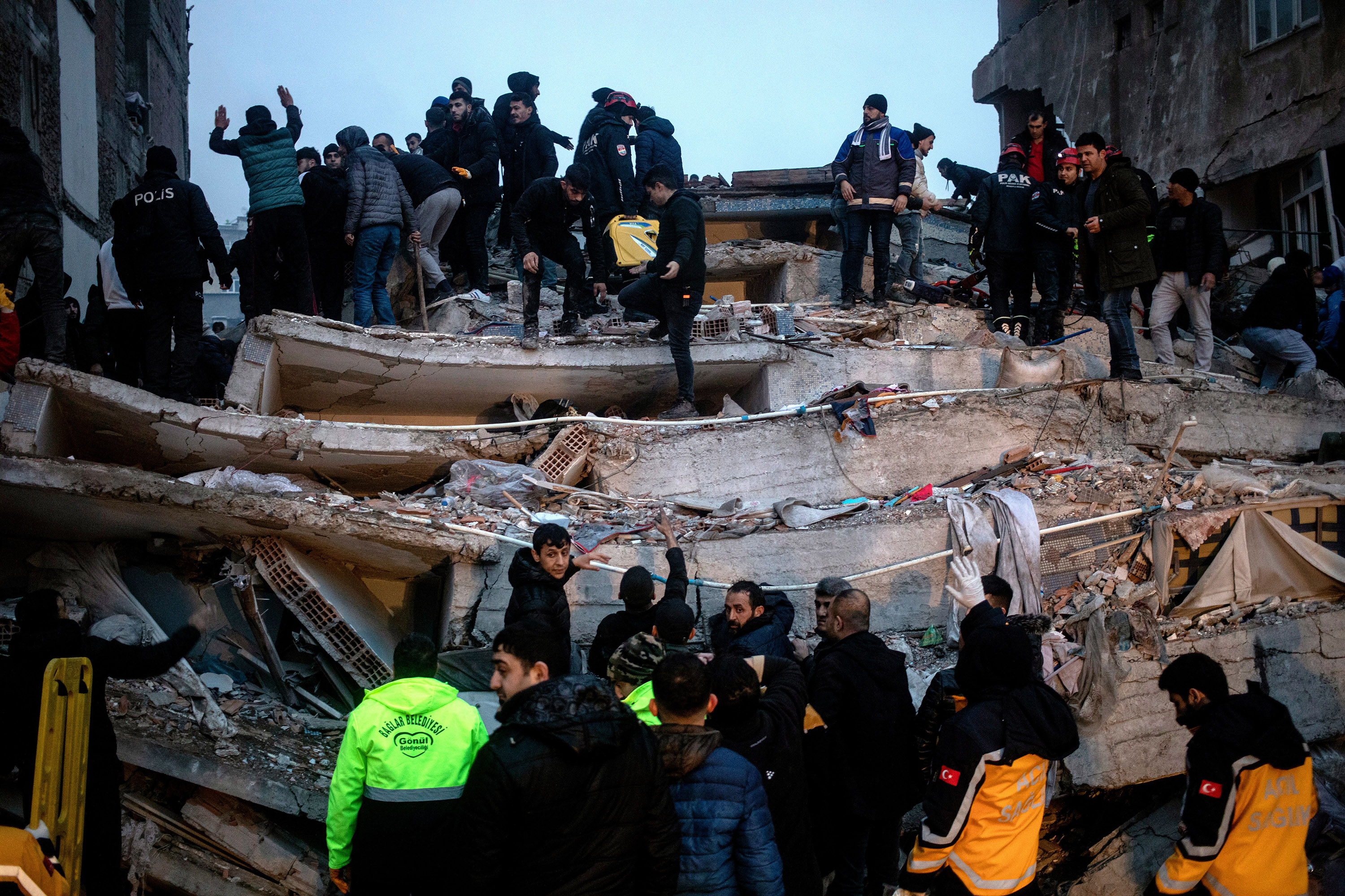 Turkish emergency personnel and others try to help victims at the site of a collapsed building after an earthquake in Diyarbakir, Turkey on February 6.