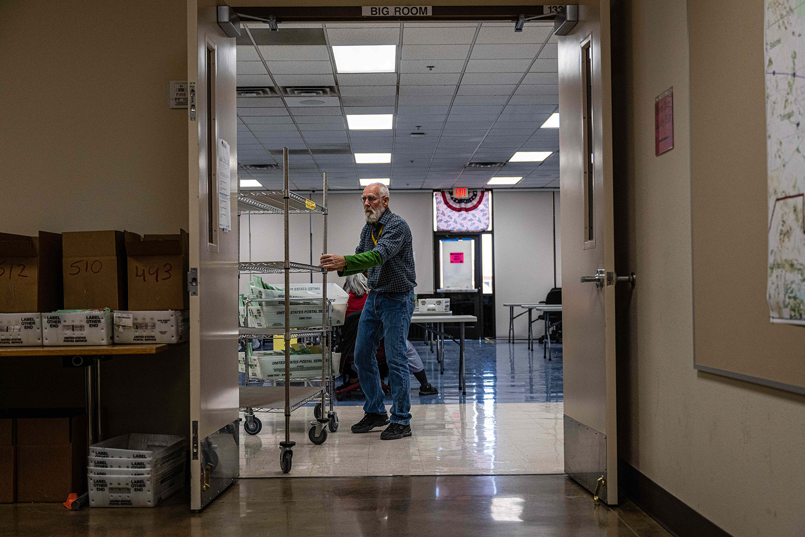 An election worker moves a rolling shelf at the Maricopa County Tabulation and Election Center in Phoenix, Arizona, on Tuesday.