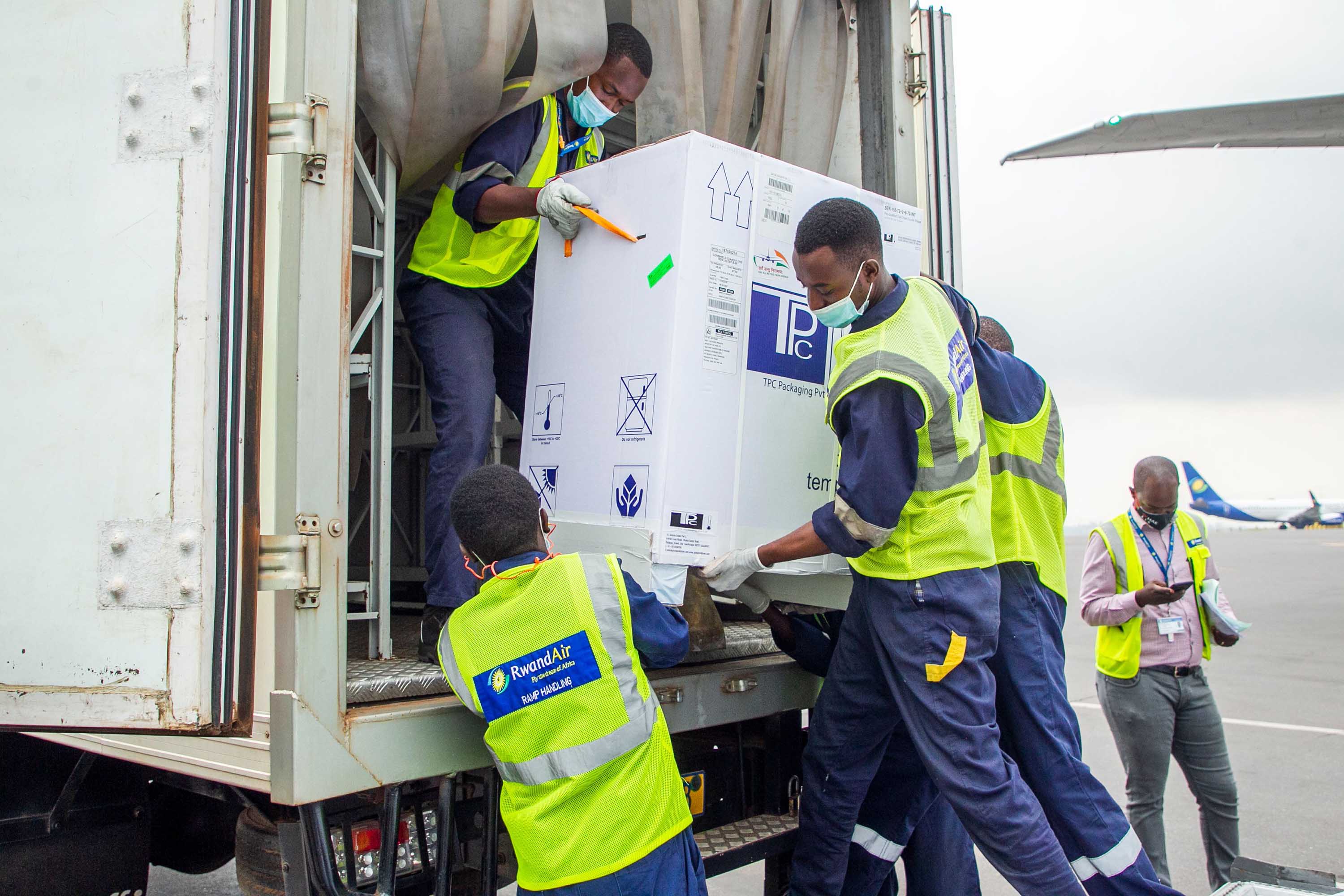 Staff transport a load of Oxford/AstraZeneca vaccines into a refrigerated vehicle during the arrival of the first batch of doses at the Kigali International Airport in Kigali, Rwanda, on March 3. 