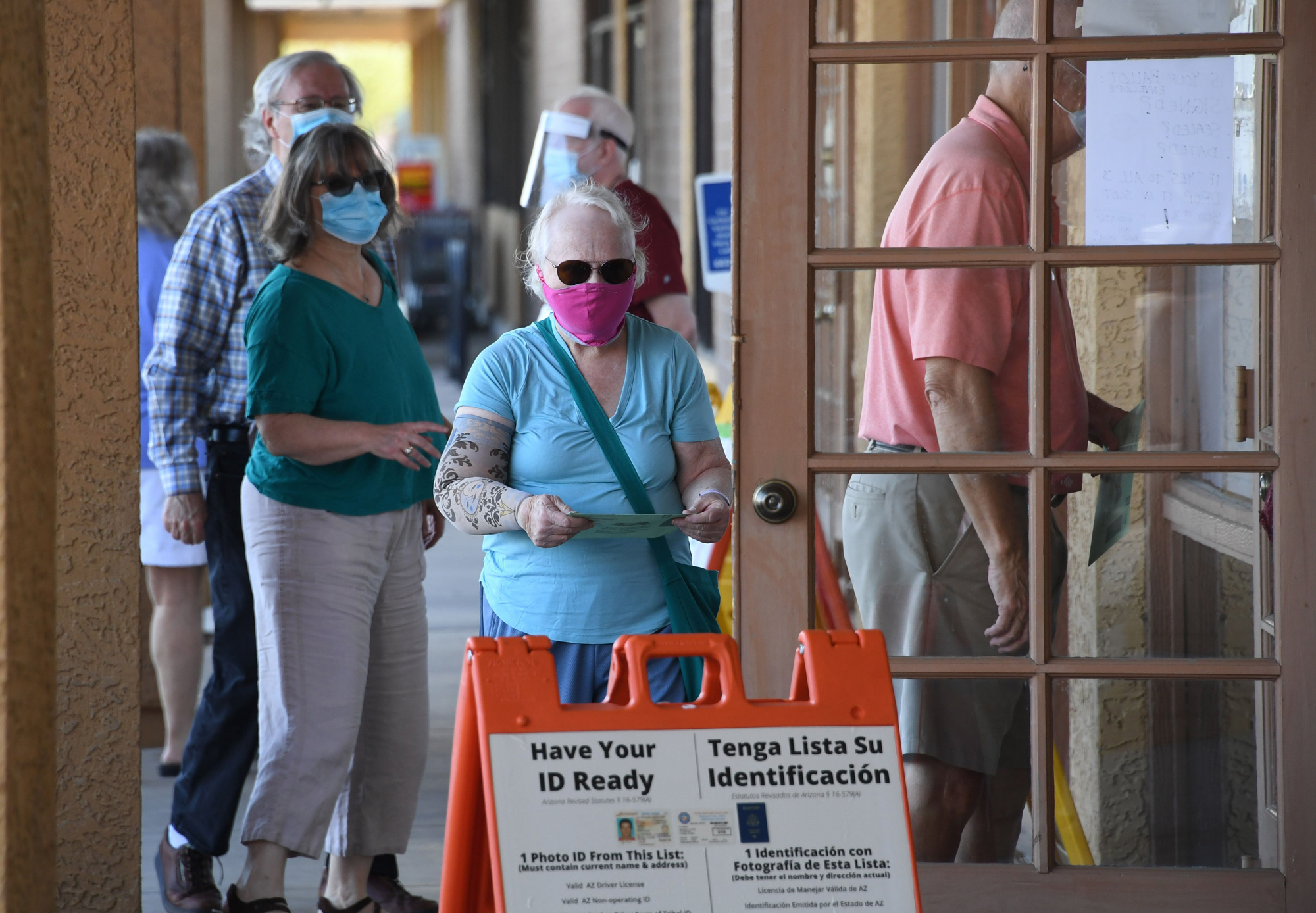 People wait in line to drop off mail-in ballots at an early voting location in Phoenix, Arizona, on October 16.