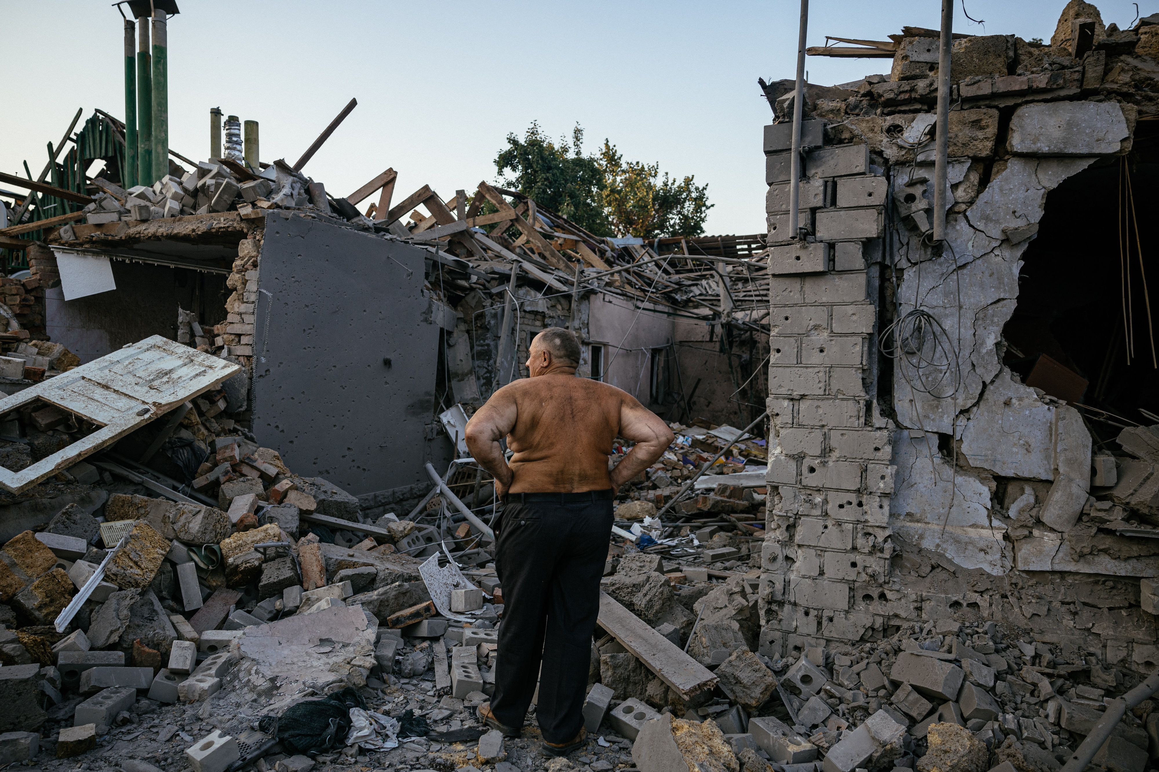 Oleksandr Shulga looks at his destroyed house following a missile strike in Mykolaiv, southern Ukraine, on August 29, 2022, 