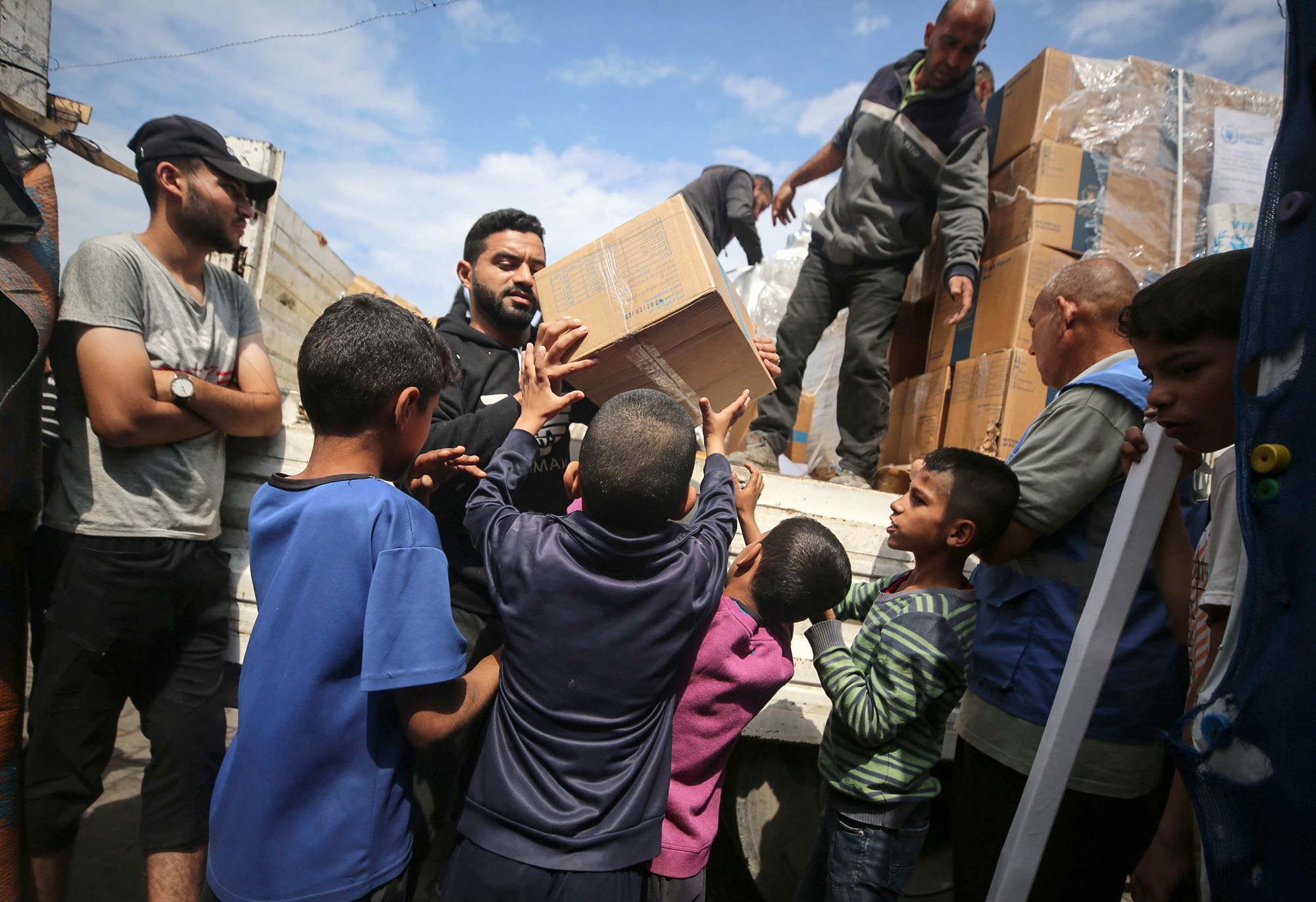 A Palestinian is carrying boxes of aid distributed before the Eid al-Fitr holiday in Deir Al-Balah, Gaza, on April 8.