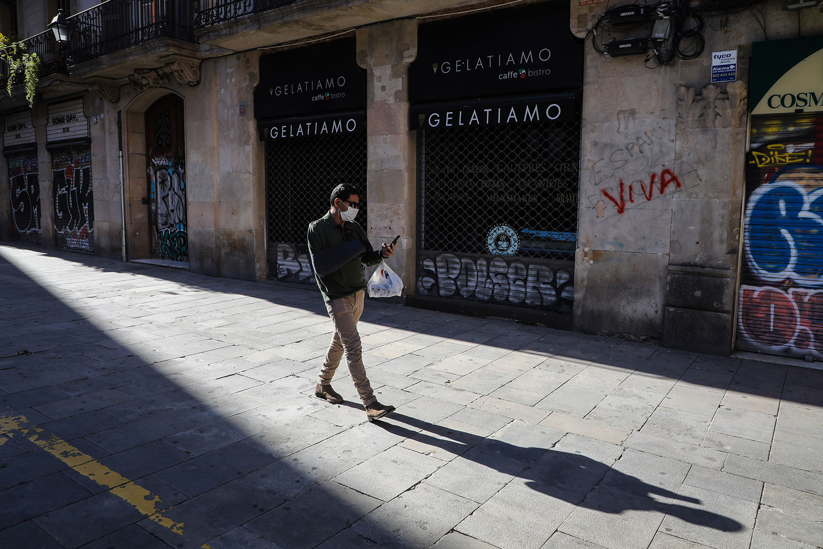 A pedestrian walks past closed stores in Barcelona, Spain, on April 30.