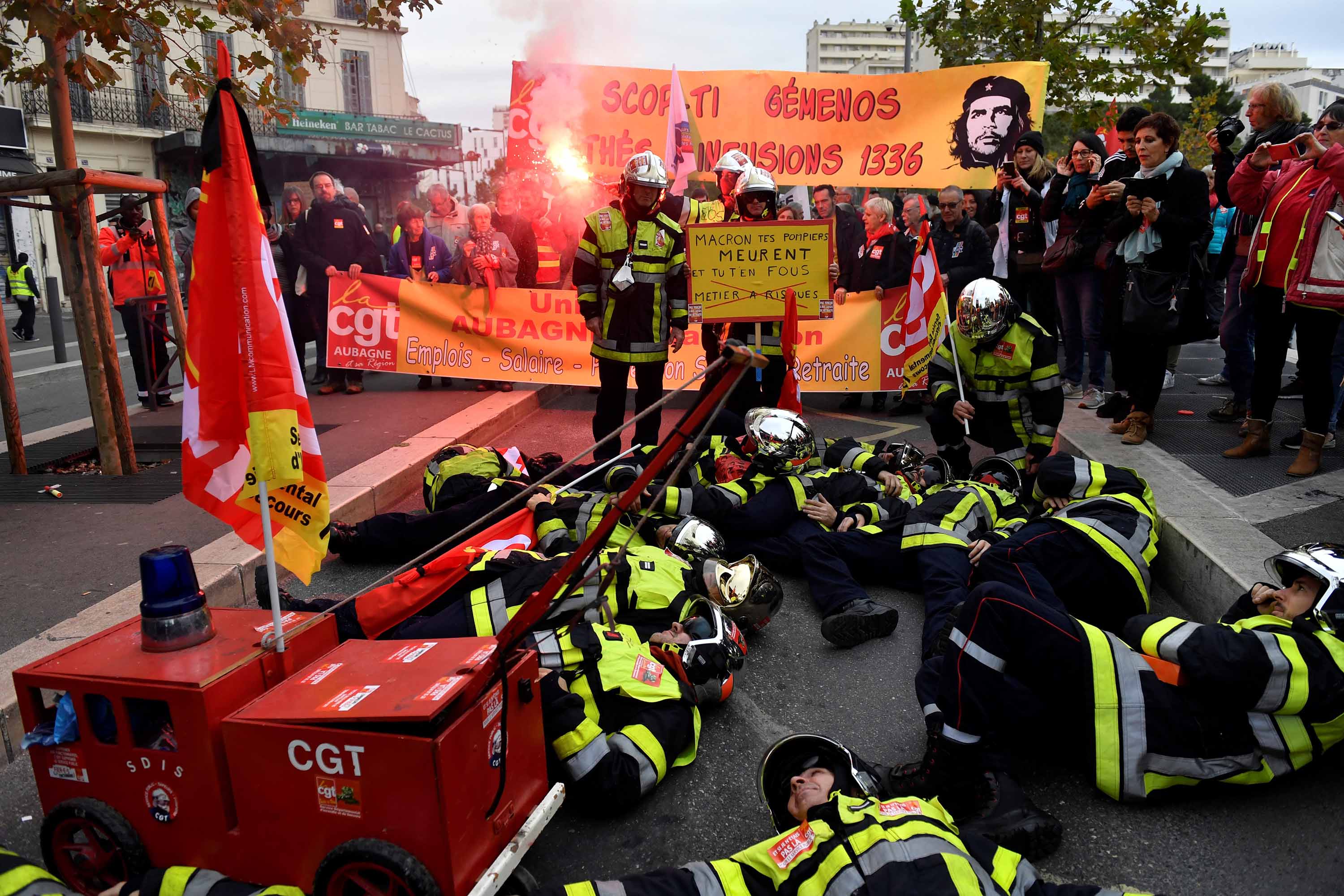 Firefighters lay on the ground as they take part in a demonstration to protest the proposed pension overhauls, in Marseille. Photo: Clement Mahoudeau/AFP via Getty Images