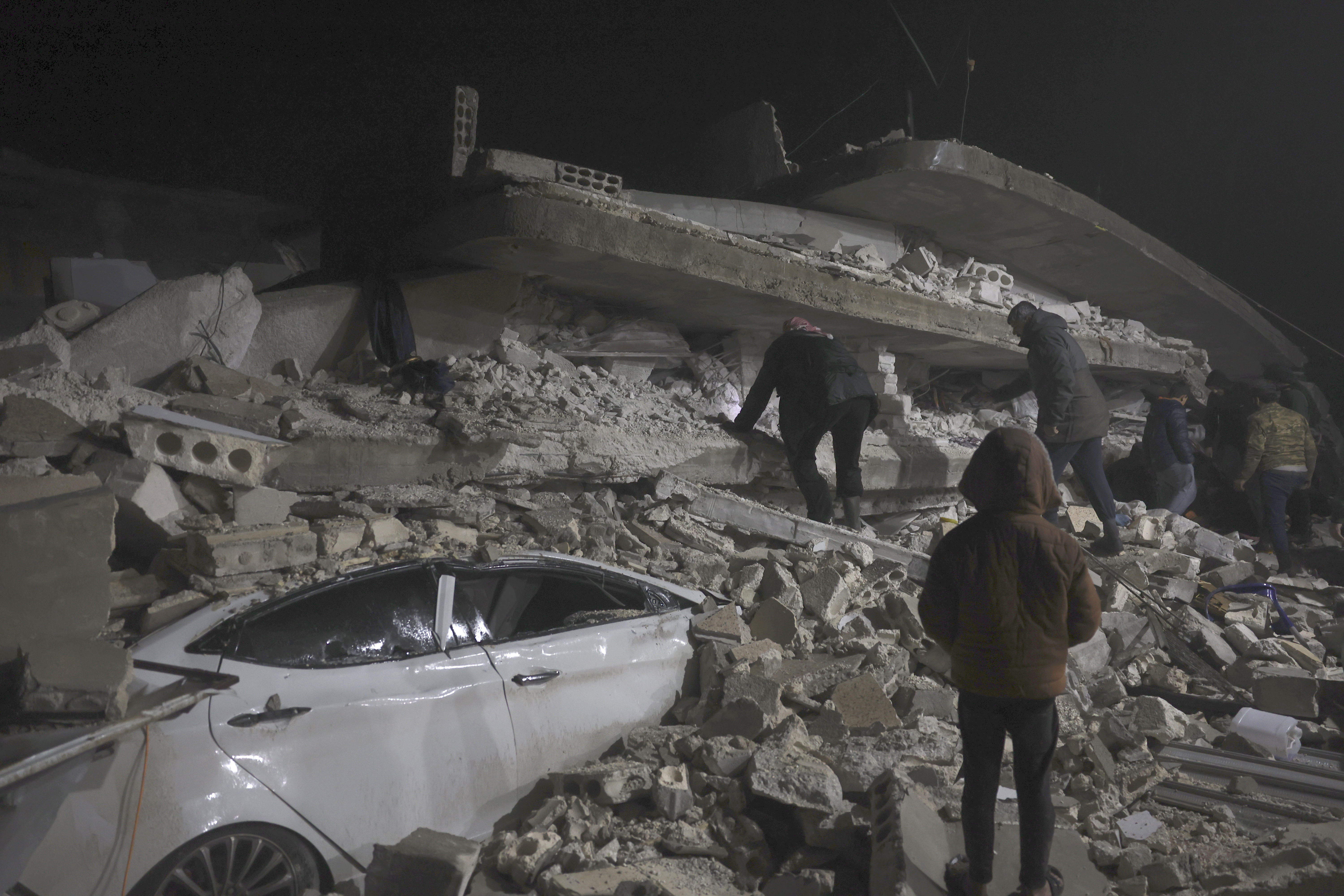 People search through the wreckage of a collapsed building in Idlib, Syria, on February 6.