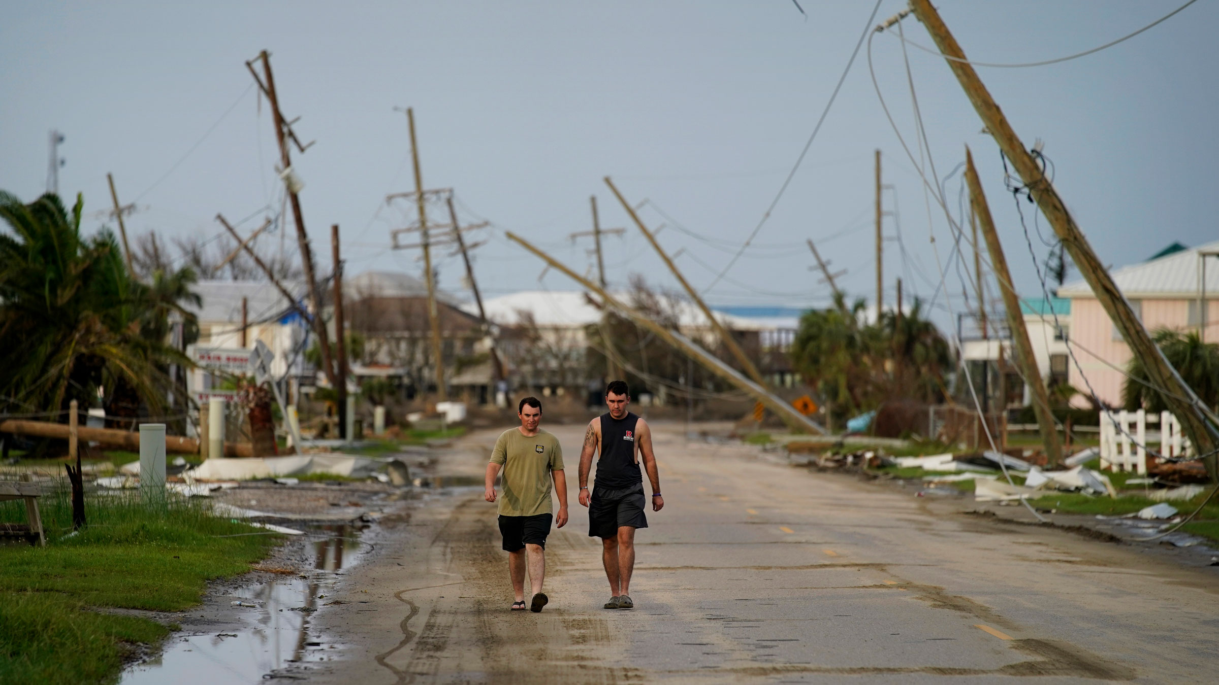 People walk through a damaged neighborhood in Grand Isle, Louisiana, on Monday.