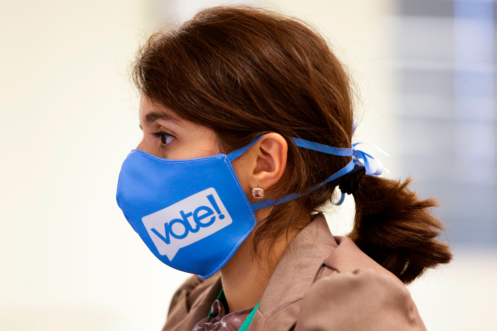 Election Worker Darleen Jara wears a face mask with "vote!" written on it as she handles signature verifications as vote-by-mail ballots for the August 4 Washington state primary are processed at King County Elections in Renton, Washington on August 3.