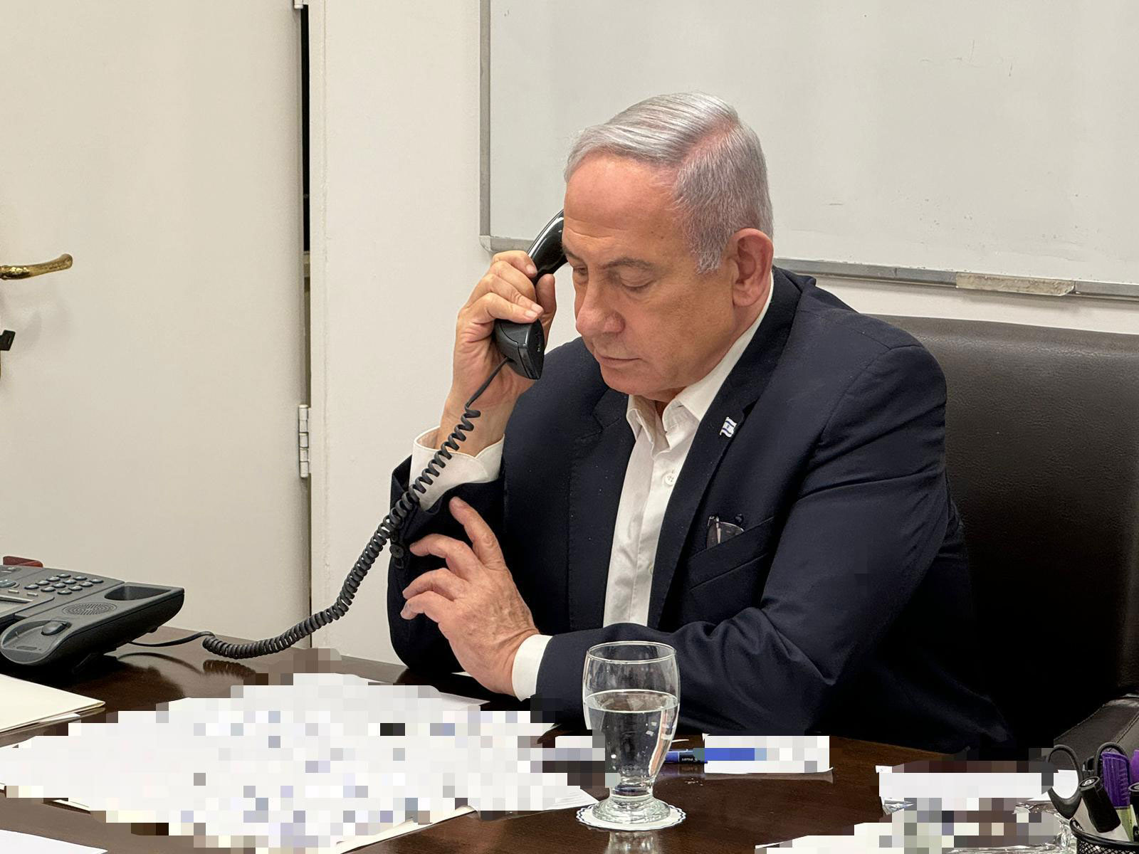 In this handout photo, released early Sunday local time, Israeli Prime Minister Benjamin Netanyahu talks on the phone with US President Joe Biden. Portions of this photo have been blurred by the source. 