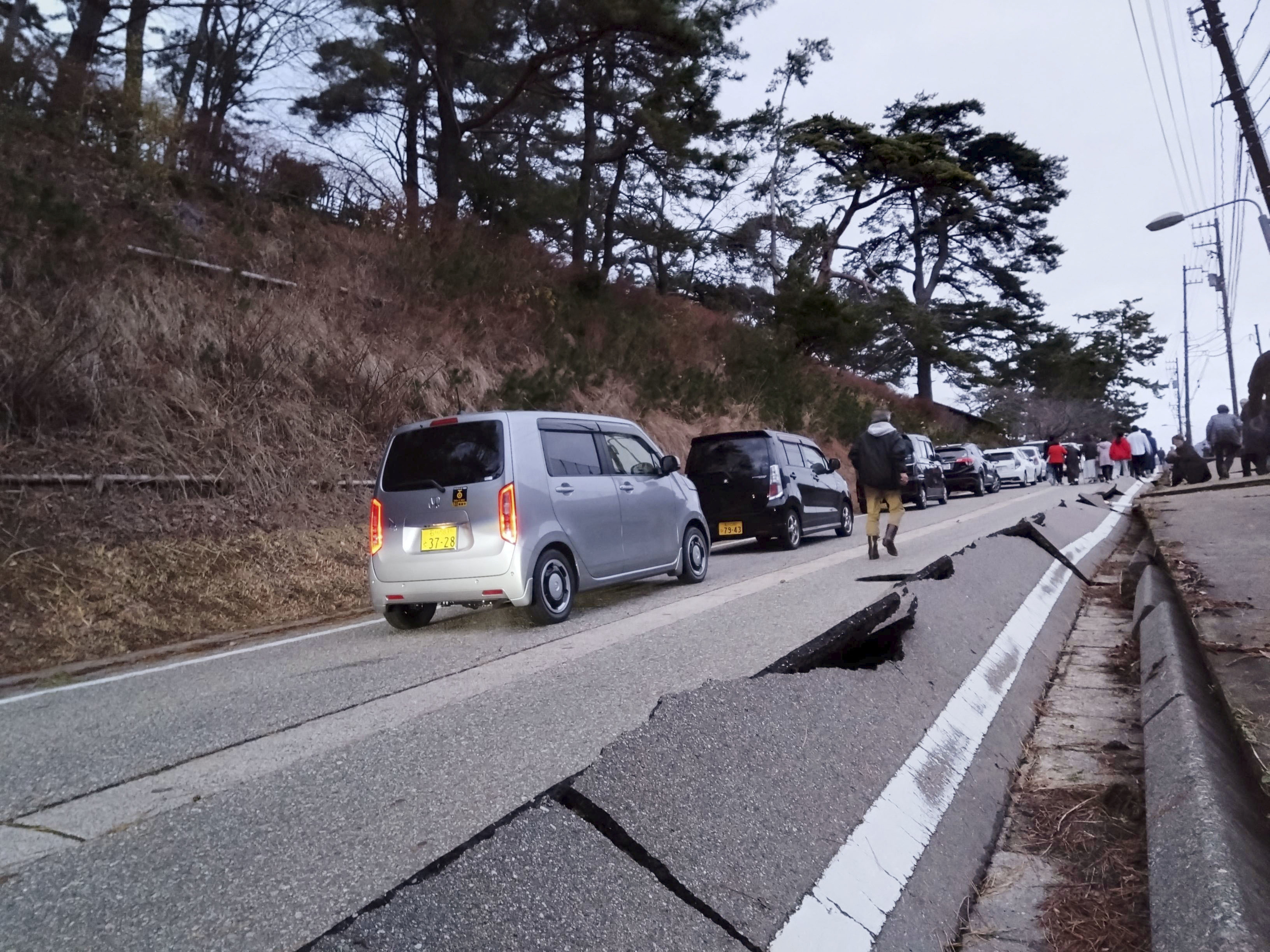 People walk along a road damaged by an earthquake in Wajima, Ishikawa prefecture, Japan, on January 1.