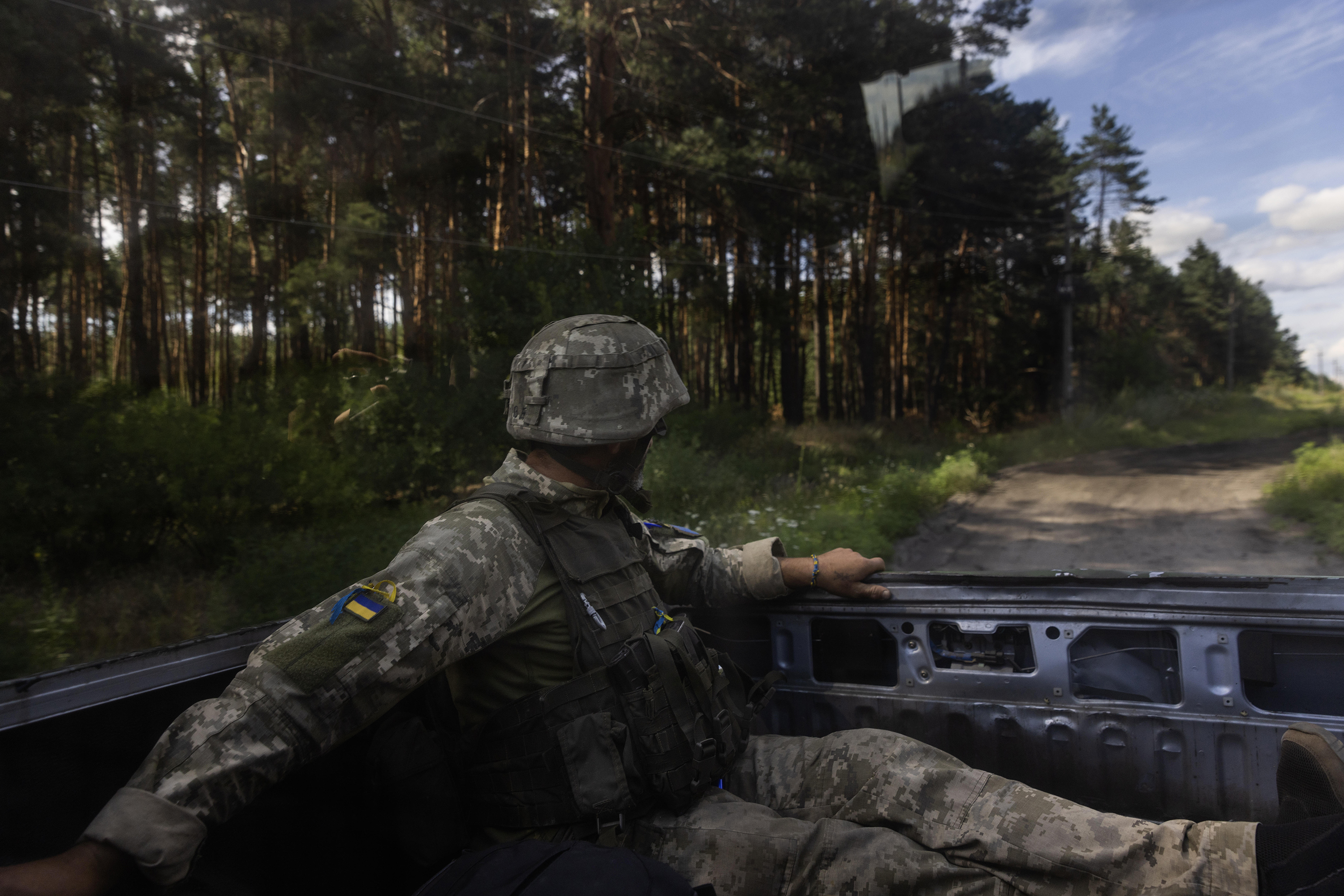 A Ukrainian infantry soldier catches a ride to a fighting position near Kupyansk, Ukraine, after being treated due to shrapnel wounding on the back during an attack, on July 12.