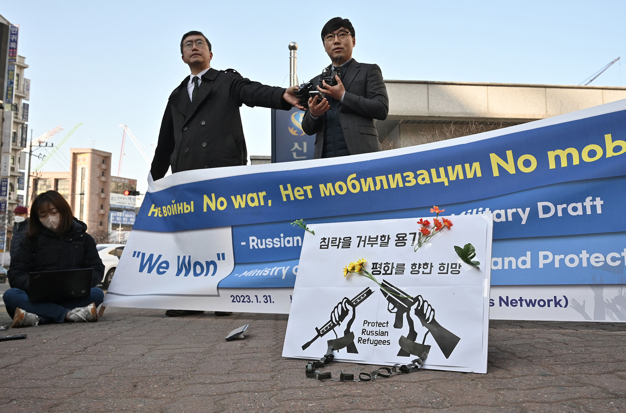 South Korean attorneys Lee Jong-chan, right, and Lee Il, center , who represent Russian asylum seekers stranded at Incheon International Airport, speak to reporters outside the district court in Incheon, South Korea, on February 14.