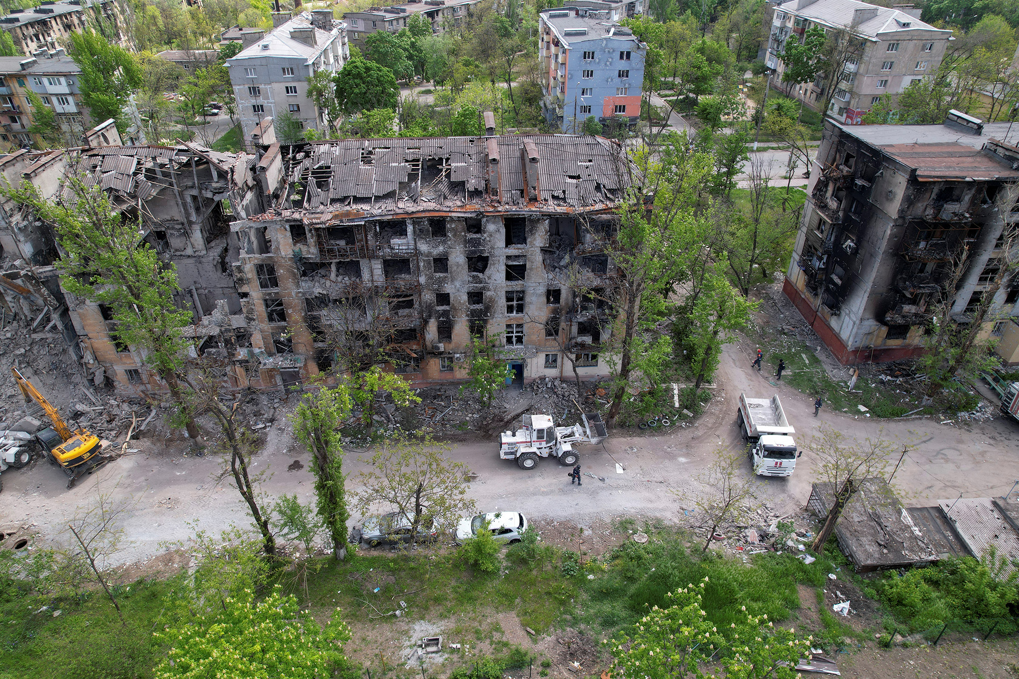 Emergency management specialists remove debris around a residential building destroyed in the Russian invasion of Mariupol, Ukraine, on May 11.