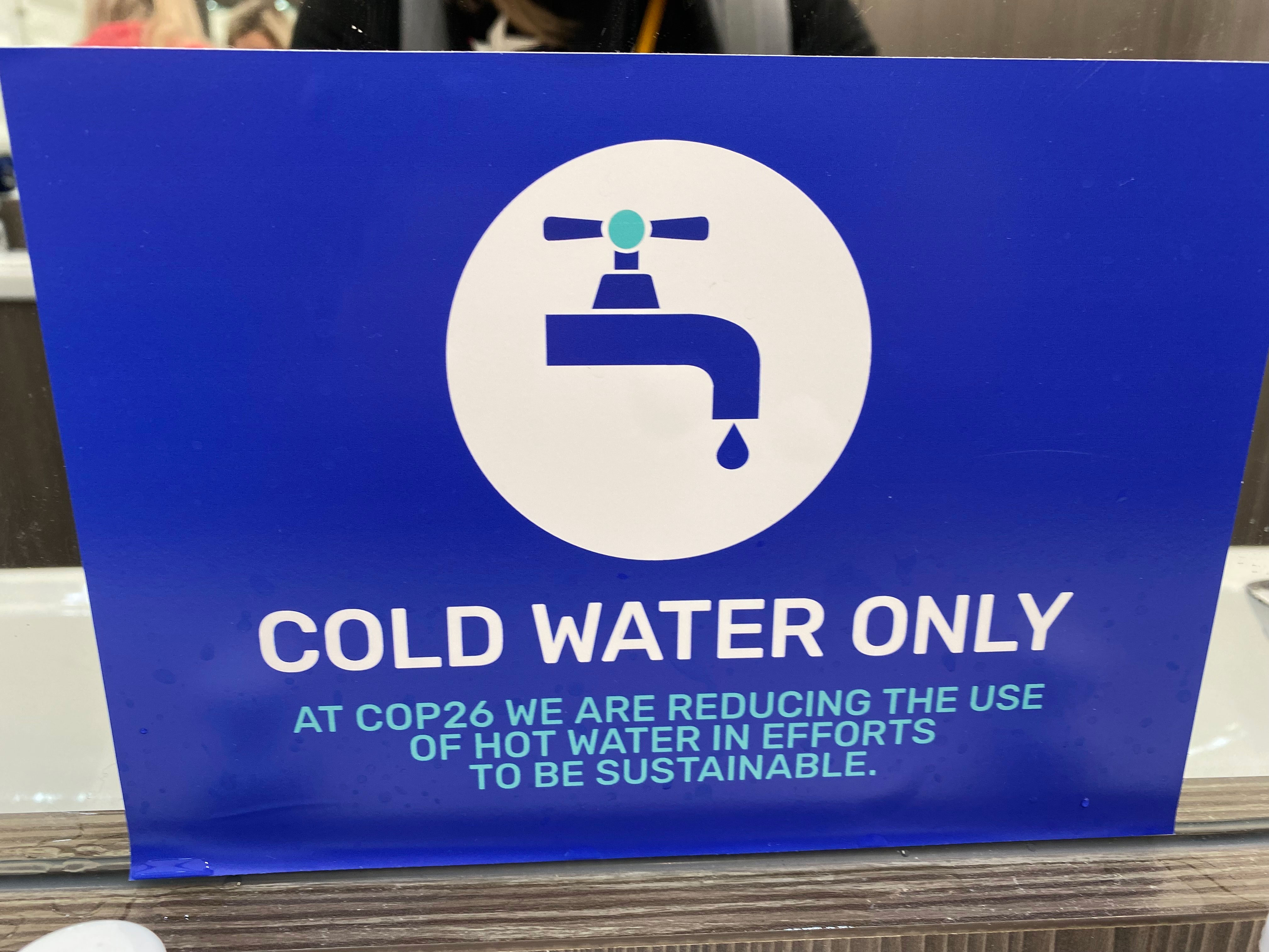 A sign about "cold water only" is in a bathroom at COP26 on November 1.
