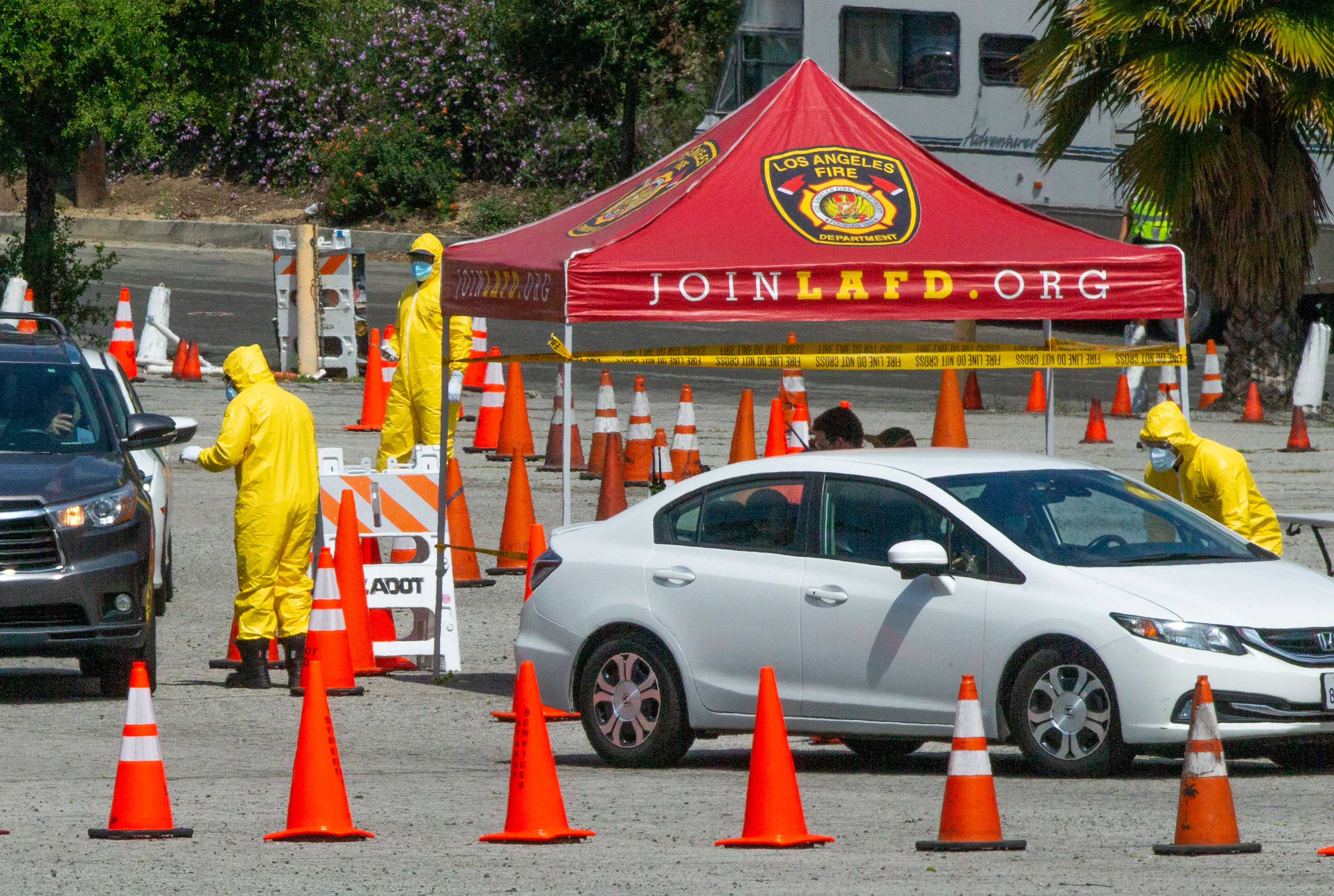 Los Angeles Fire Department officials wearing protective gear administer coronavirus tests at a drive-up testing site in Elysian Park, Los Angeles on April 2.