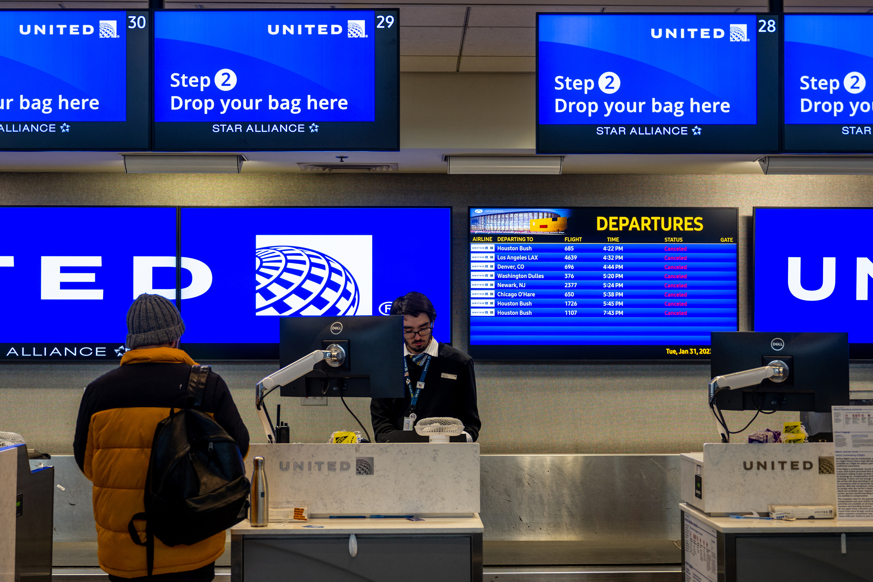 A traveler waits at a United Airlines counter at the Austin-Bergstrom International Airport on Tuesday in Austin, Texas. Many flights have been delayed and cancelled due to a winter storm.