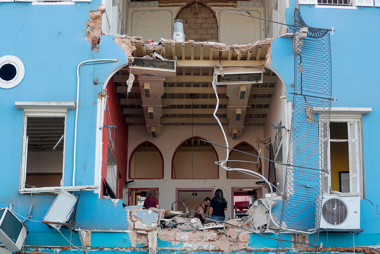 A Lebanese couple inspect the damage to their house in an area overlooking the destroyed Beirut port on August 5.