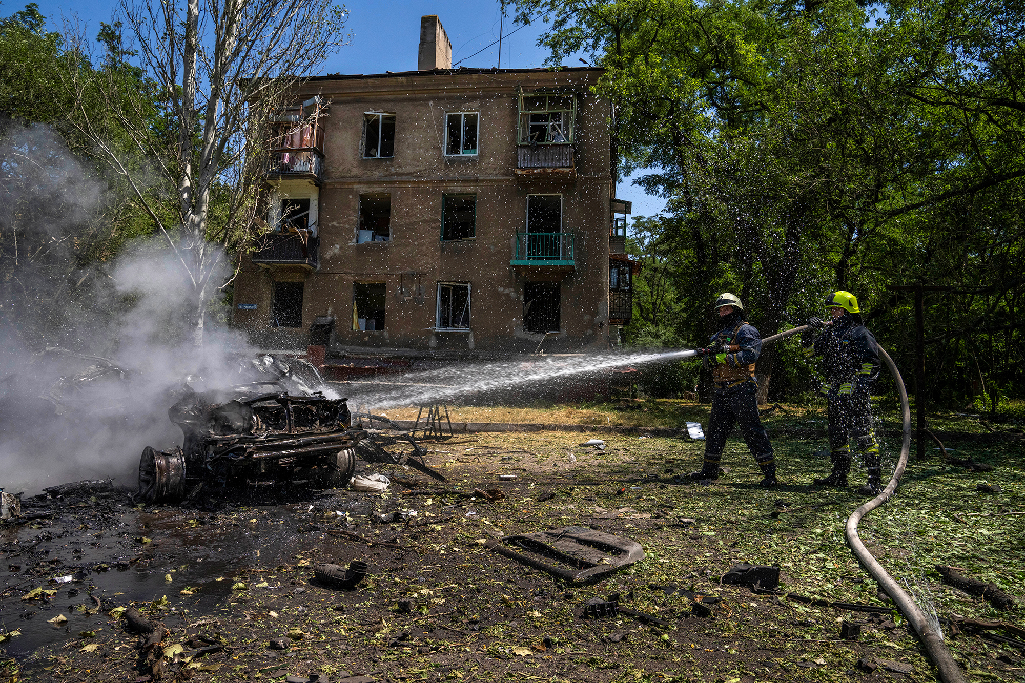 Firefighters hose down a burning car in Kramatorsk on July 7. 