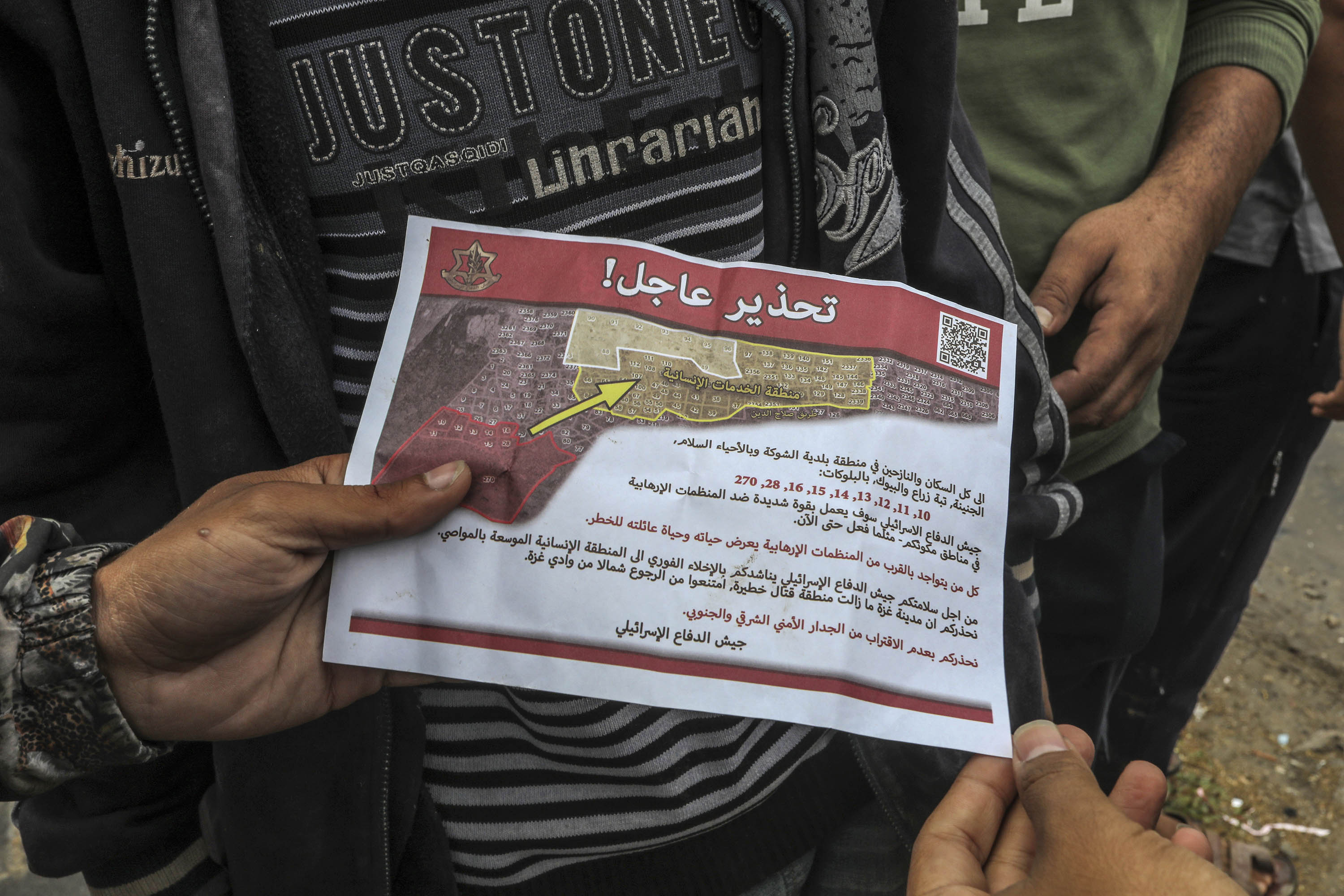 A person holds a leaflet dropped over Rafah by Israeli military aircraft, ordering people in parts of eastern Rafah to evacuate, on May 6. 