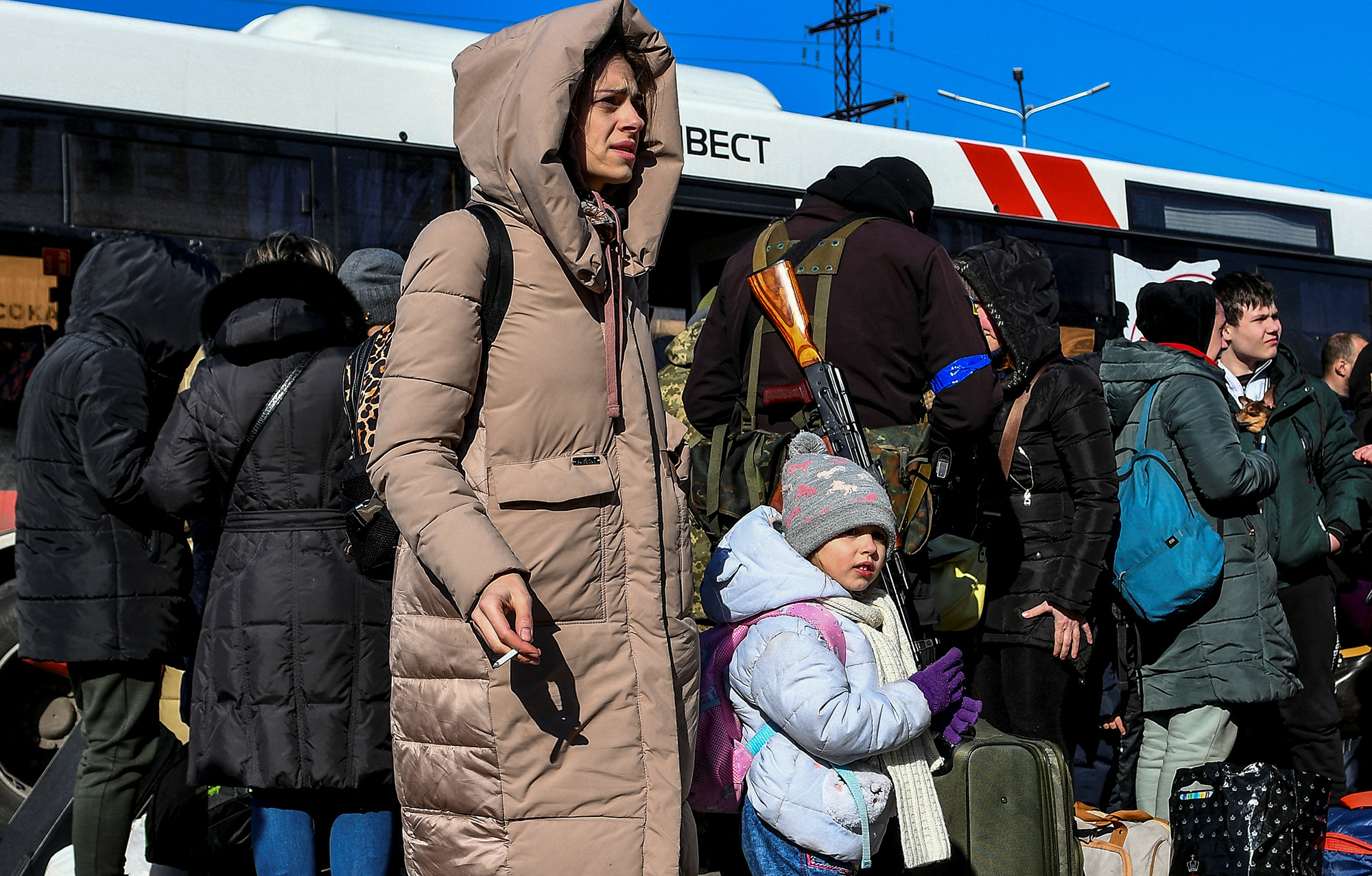 People stand next to an evacuee bus after fleeing from Mariupol to Zaporizhzhia, Ukraine, on March 19.