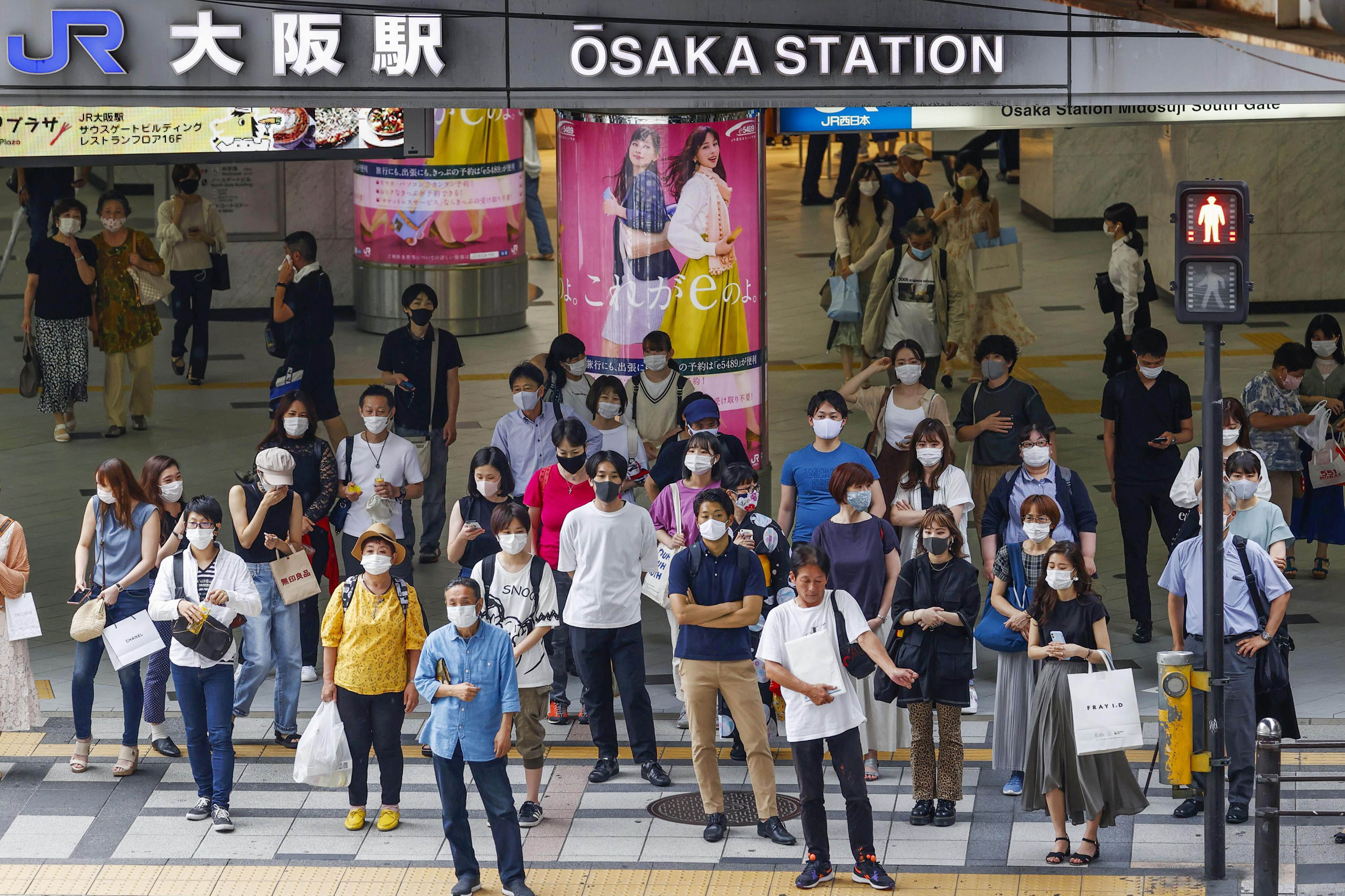 People wearing face masks are seen in front of Osaka Station on July 22, amid the spread of the novel coronavirus. 