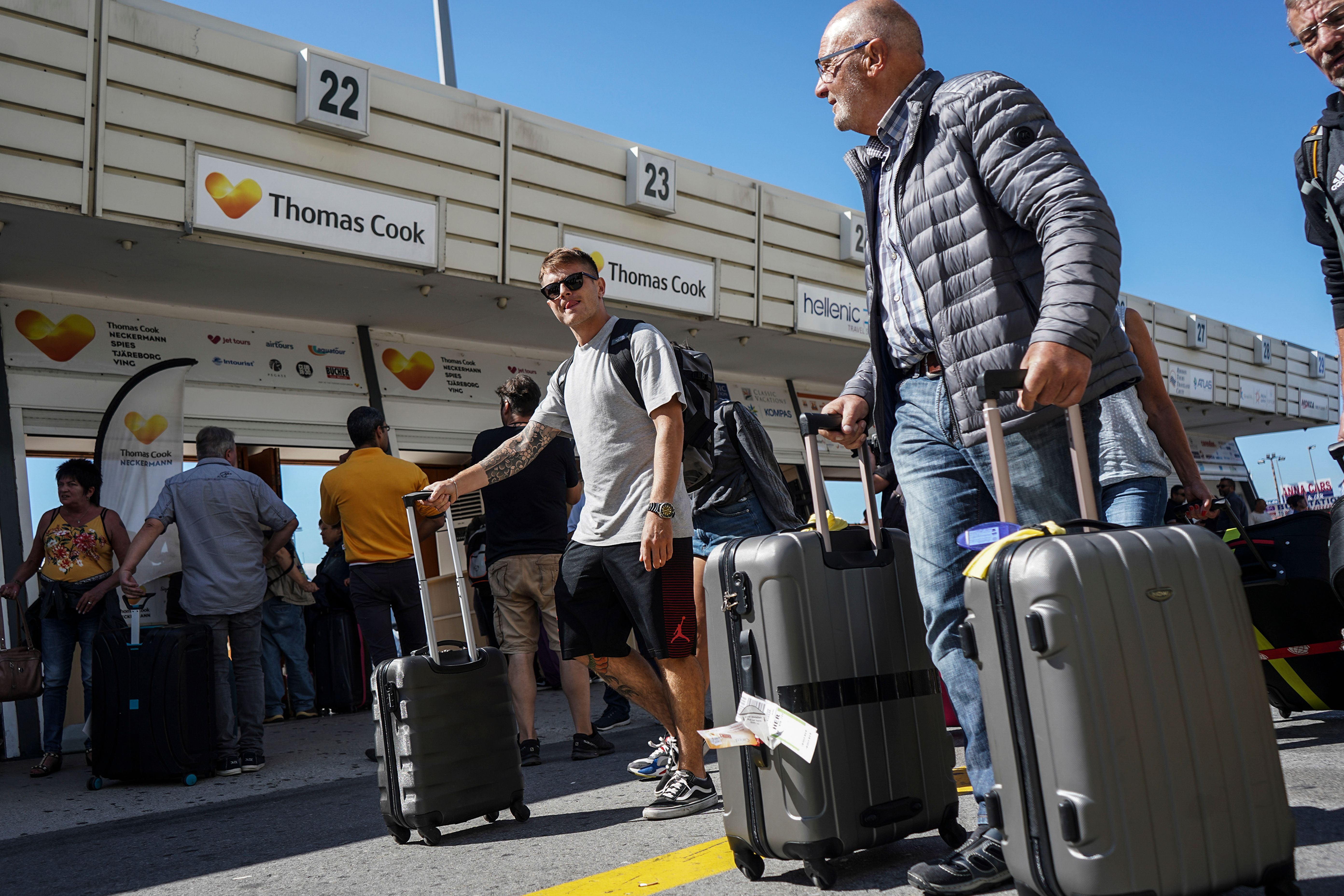 Tourists wait at a Thomas Cook company counter at the Heraklion airport on the island of Crete.