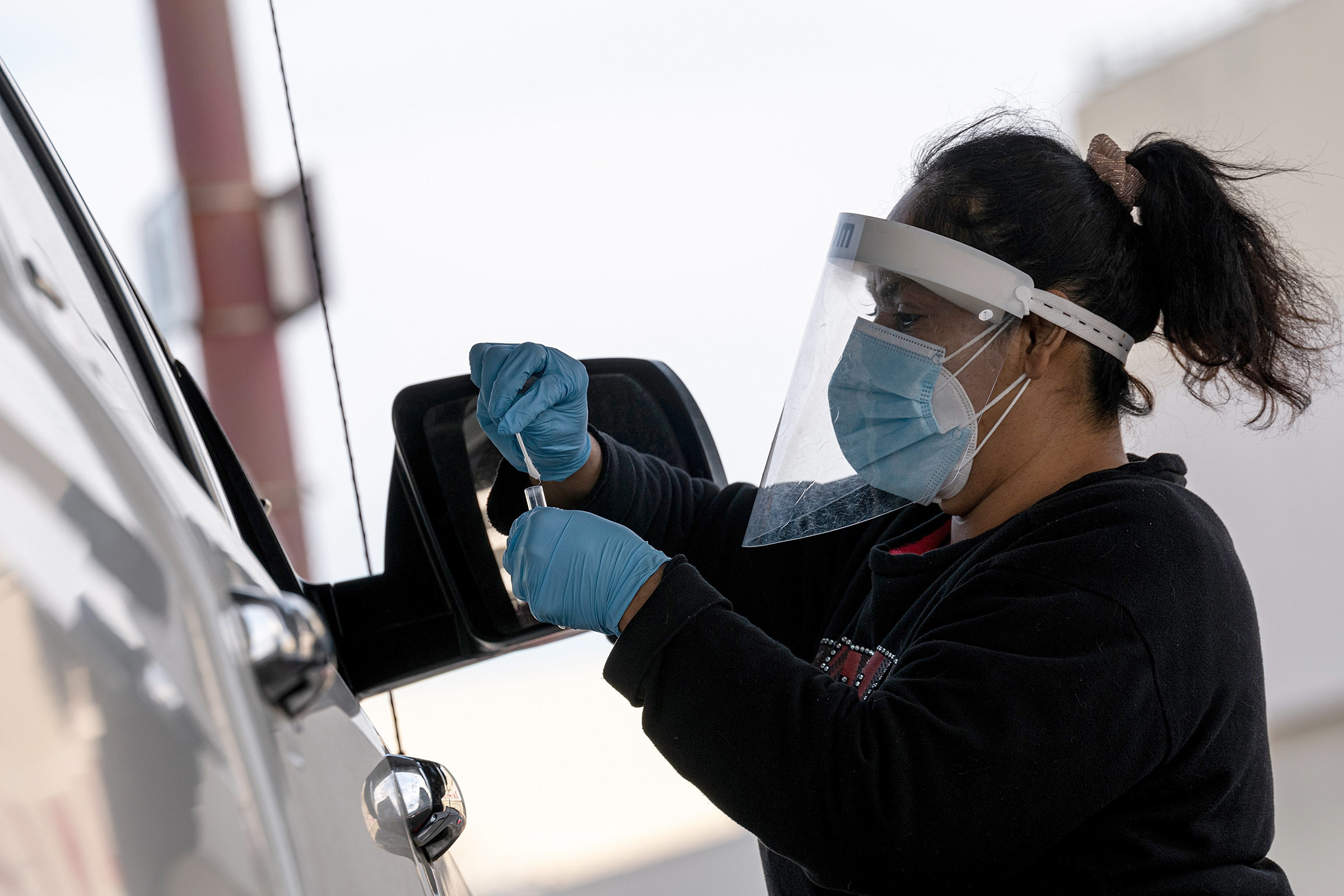 A health care worker is doing a Covid-19 test on a motorist in San Francisco, California on January 9th. 