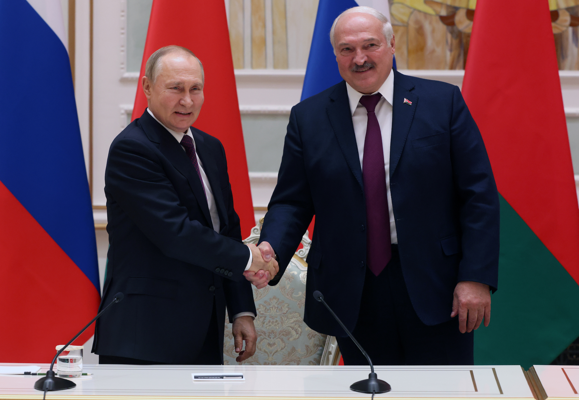 Vladimir Putin and Belarusian President Alexander Lukashenko shake hands before a press conference in Minsk on Monday.