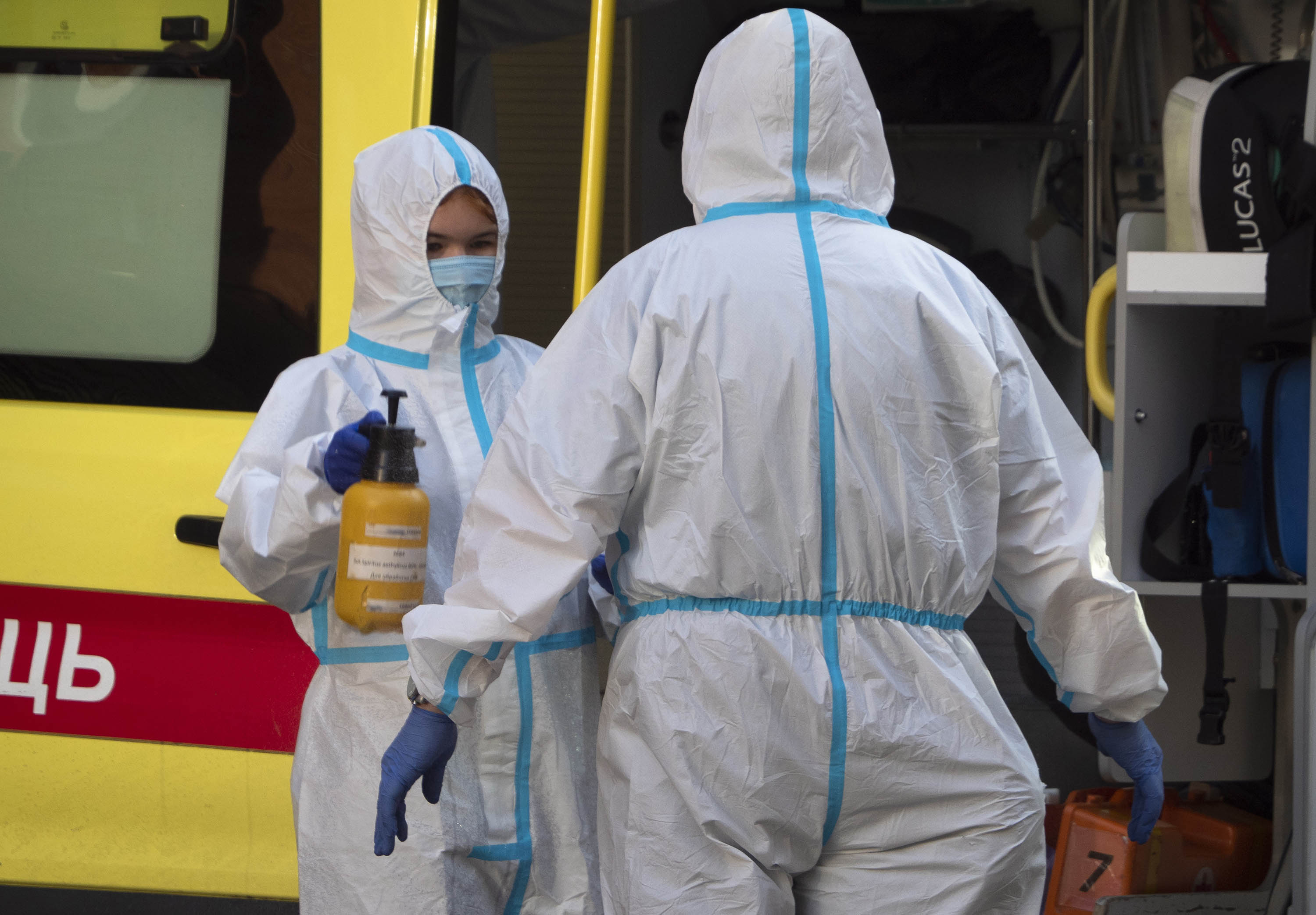 A medical worker disinfects a colleague after escorting a patient by ambulance to a hospital for COVID-19 patients in St.Petersburg, Russia, on October 1.