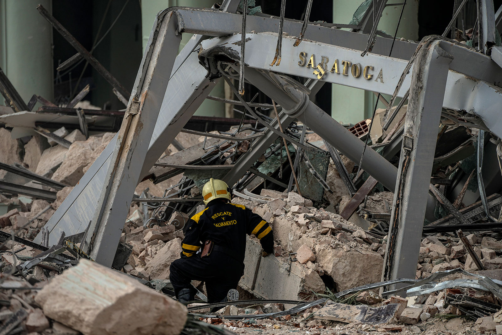 A member of a rescue team searches for survivors at the site of a deadly explosion that destroyed the Hotel Saratoga, in Havana, Cuba, on Friday, May 6. 