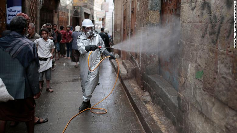 A health worker wearing a protective suit sprays disinfectant at a market in the old city of Sanaa in April.