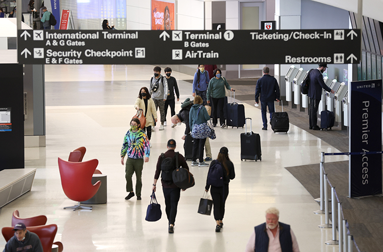 Airline passengers walk through San Francisco International Airport on April 19.